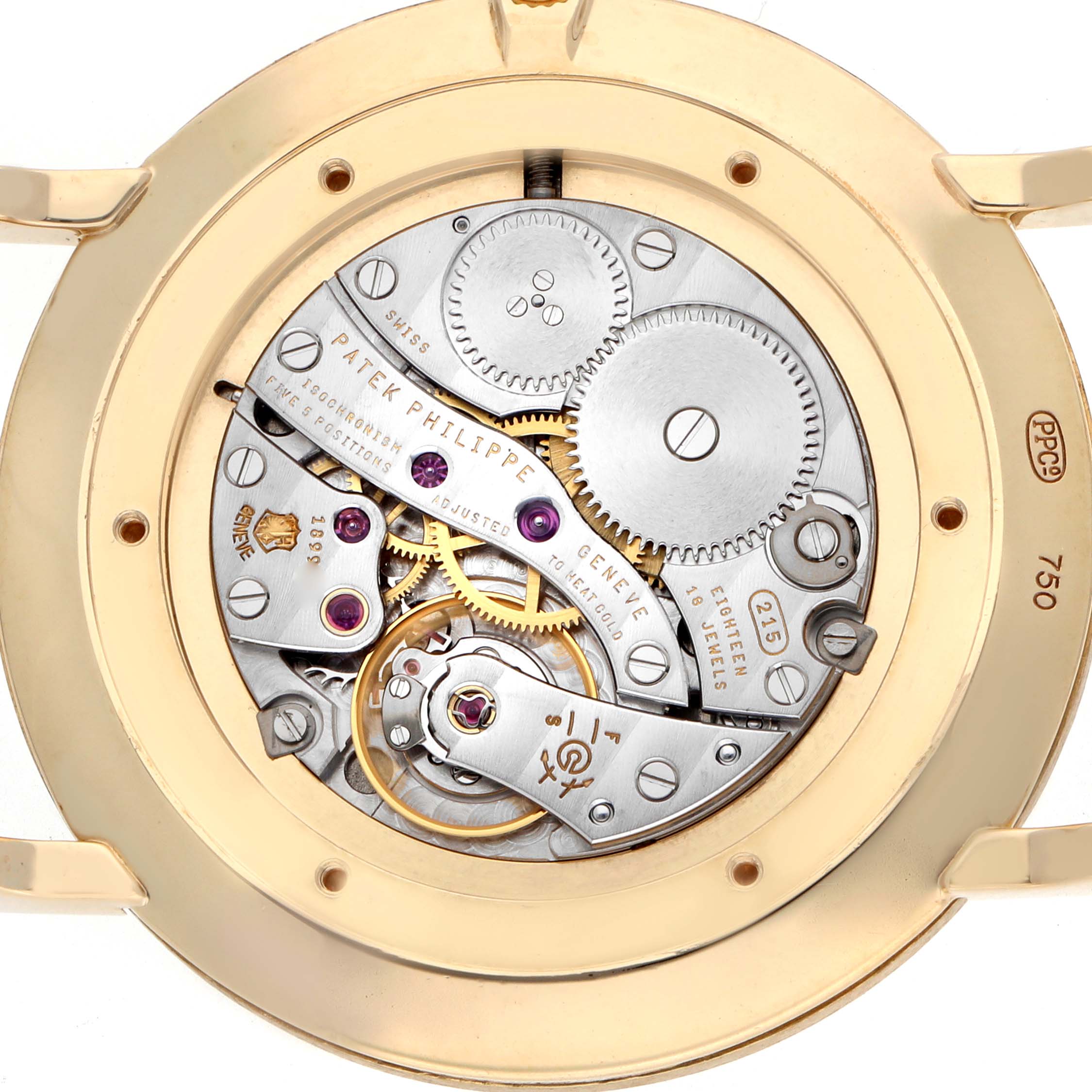 The image shows the movement of a Patek Philippe Calatrava 5119J-001 Men
s Yellow Gold White Dial watch from a rear angle, revealing gears and inscriptions.