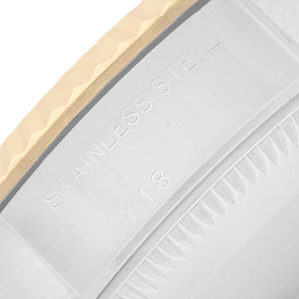 The image shows a close-up of the side of a Rolex Datejust 79173 Women
s Steel and Gold (two tone) Champagne Dial watch bezel, featuring the "Stainless Steel" engraving.