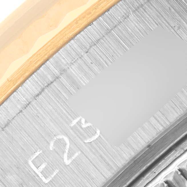 This is a close-up angle of the case side and rehaut of a Rolex Datejust 69173 Women's Steel and Gold (two tone) Champagne Dial 69173 Women's Steel and Gold (two tone) Champagne Dial watch, showing part of the serial number.