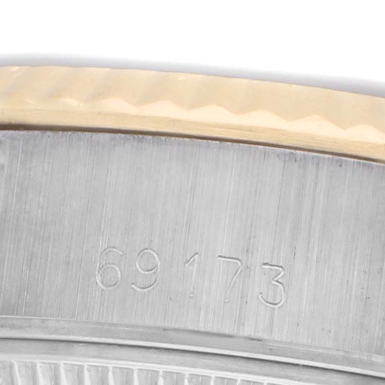 The image shows a close-up of the side of a Rolex Datejust 69173 Women
s Steel and Gold (two tone) Black Dial watch with a focus on the serial number engraving.
