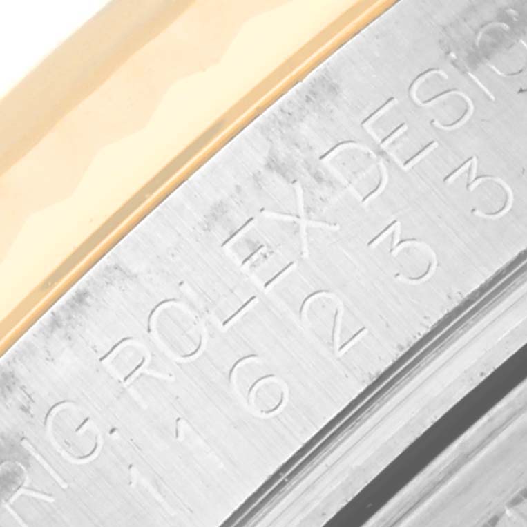 The image shows a close-up of the stainless steel case with engraved text on a Rolex Datejust 116233 Men
s Steel and Gold (two tone) Silver Dial 116233 Men
s Steel and Gold (two tone) Silver Dial watch, highlighting its edge.