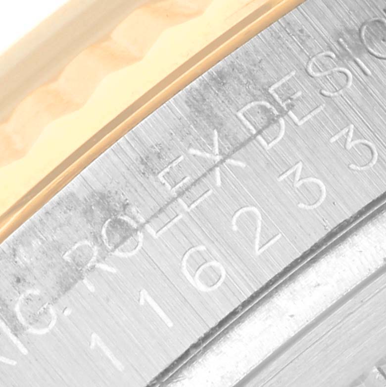 This image shows a close-up of the engraved bezel and serial number of a Rolex Datejust 116233 Men's Steel and Gold (two tone) White Dial 116233 Men's Steel and Gold (two tone) White Dial watch.