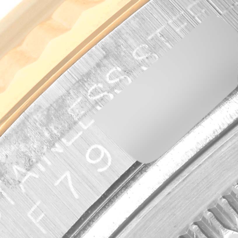 This image shows a close-up of the serial number and part of the bezel of a Rolex Datejust 116233 Men's Steel and Gold (two tone) White Dial 116233 Men's Steel and Gold (two tone) White Dial watch.