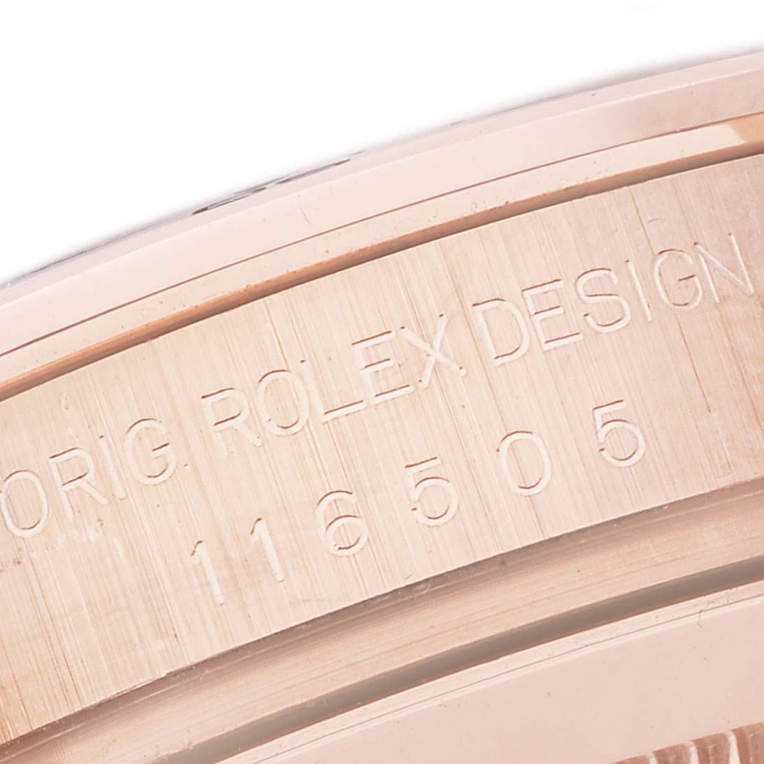 The close-up image shows the engraved inner bezel of a Rolex Daytona 116505 Men
s Rose Gold Black Dial 116505 Men
s Rose Gold Black Dial watch, featuring the model number and "ORIG ROLEX DESIGN."