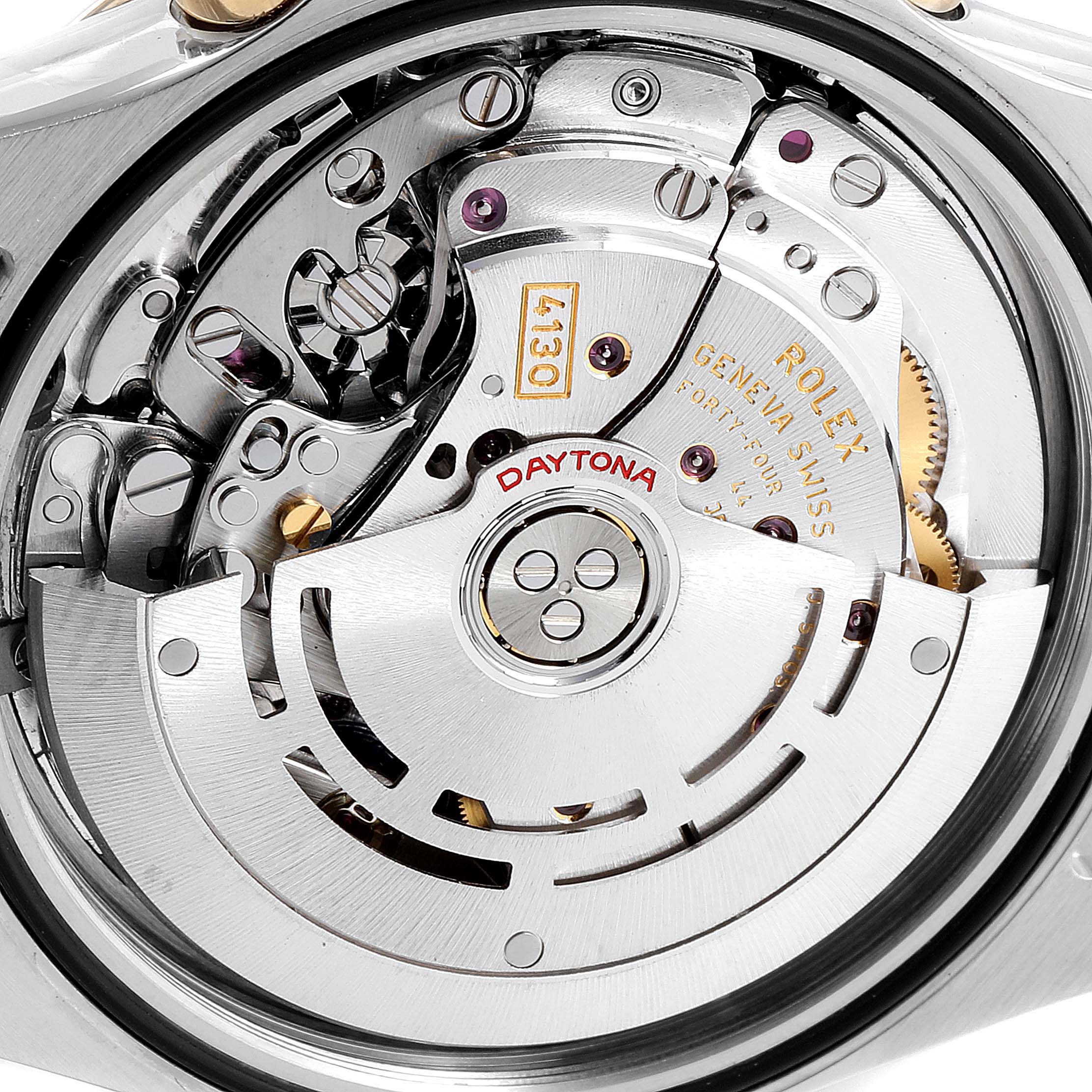 This is a close-up view of the inner mechanism of a Rolex Daytona 116523 Men's Steel and Gold (two tone) Blue Dial 116523 Men's Steel and Gold (two tone) Blue Dial watch, highlighting the intricate movement and engravings.