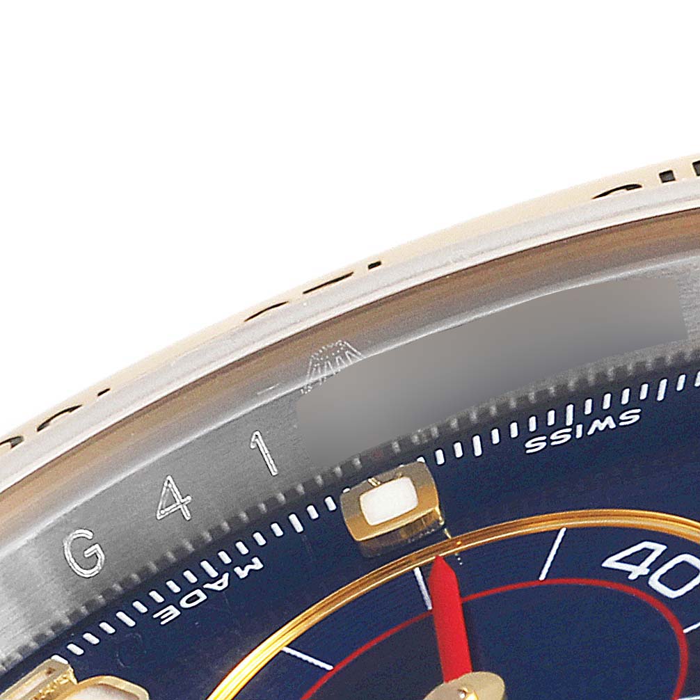 This close-up shows the upper part of the dial and bezel of the Rolex Daytona 116523 Men's Steel and Gold (two tone) Blue Dial 116523 Men's Steel and Gold (two tone) Blue Dial watch, including the numeral markings.