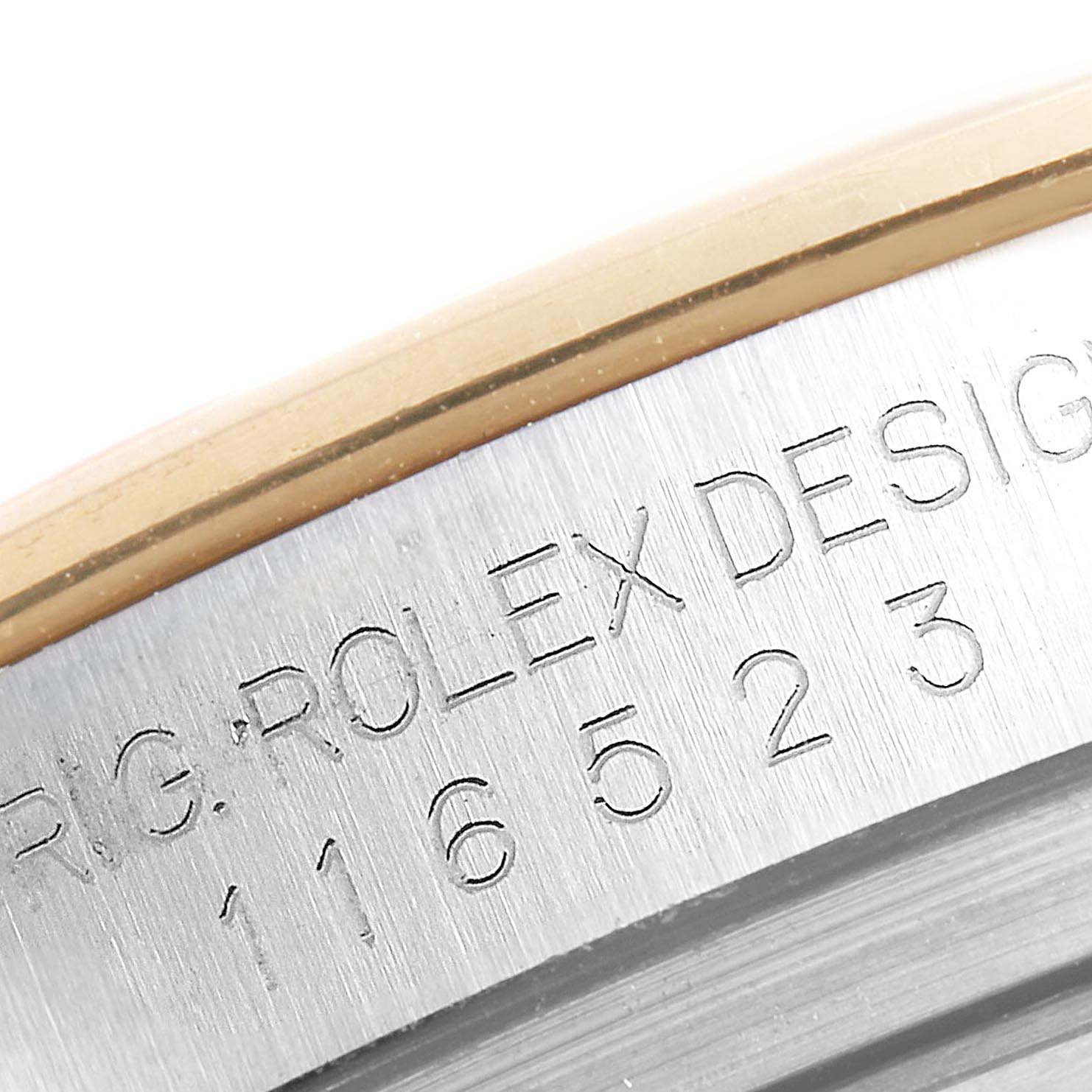 This image shows a close-up of the engraved case side of a Rolex Daytona 116523 Men's Steel and Gold (two tone) Blue Dial 116523 Men's Steel and Gold (two tone) Blue Dial watch, including the model number and inscription.