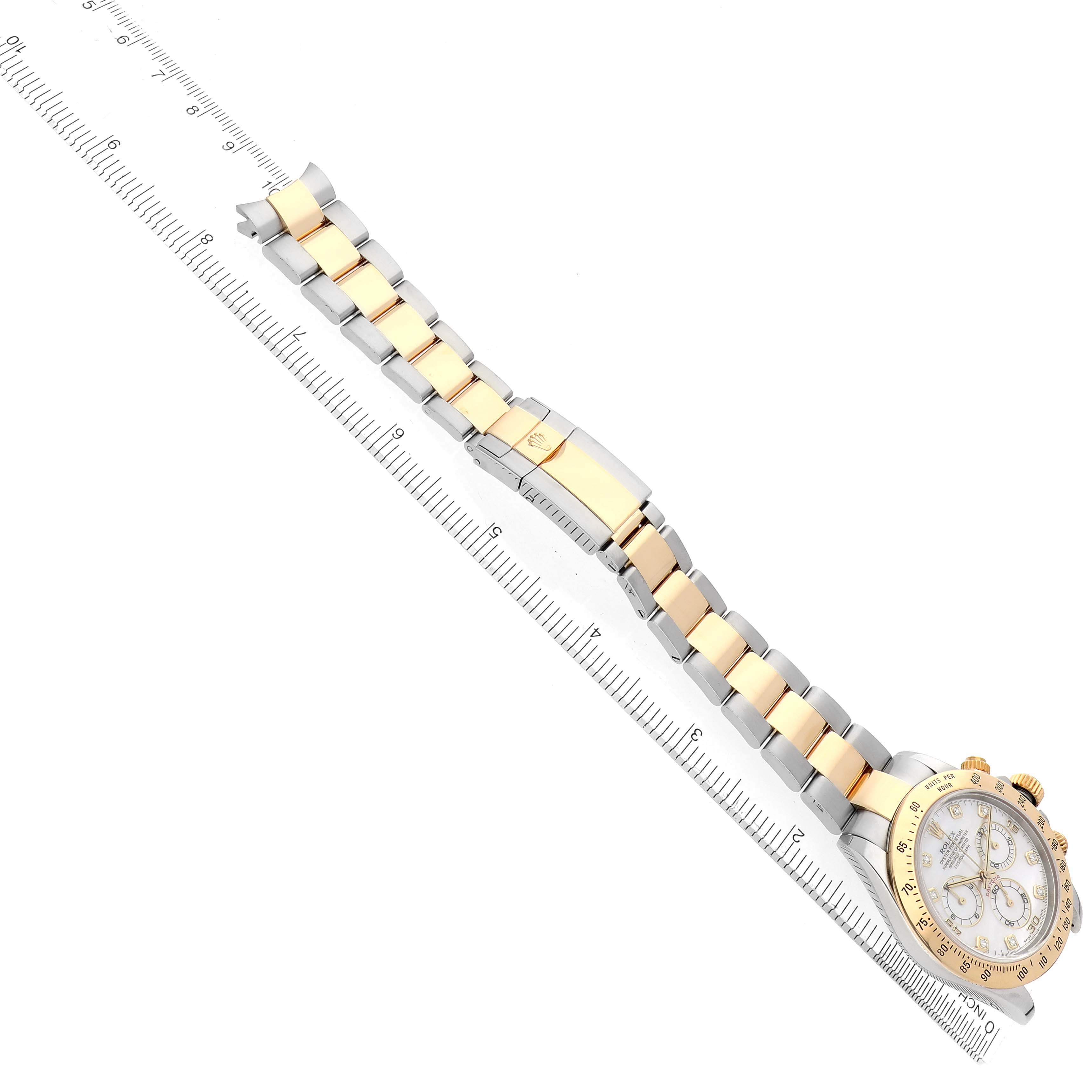 The image shows a Rolex Daytona 116523 Men
s Steel and Gold (two tone) Mother of Pearl Dial watch, including the full bracelet and face, positioned diagonally along a ruler for scale.
