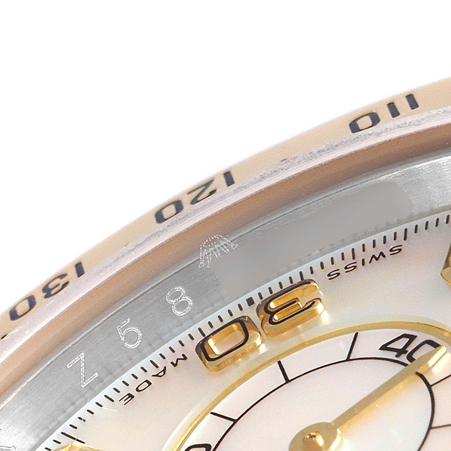 This close-up angle of the Rolex Daytona 116523 Men's Steel and Gold (two tone) Mother of Pearl Dial 116523 Men's Steel and Gold (two tone) Mother of Pearl Dial watch shows part of its bezel with the tachymeter scale and a section of the watch face.