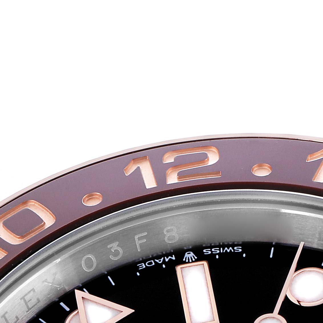 The image shows a close-up of the bezel and part of the dial of a Rolex GMT-Master 126711 Men
s Steel and Gold (two tone) Black Dial, highlighting the "12" and indices.