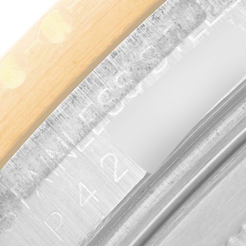 This close-up image of the Rolex GMT-Master 16713 Men's Steel and Gold (two tone) Brown Dial 16713 Men's Steel and Gold (two tone) Brown Dial shows part of the watch case, focusing on the bezel and engraved inner rim.