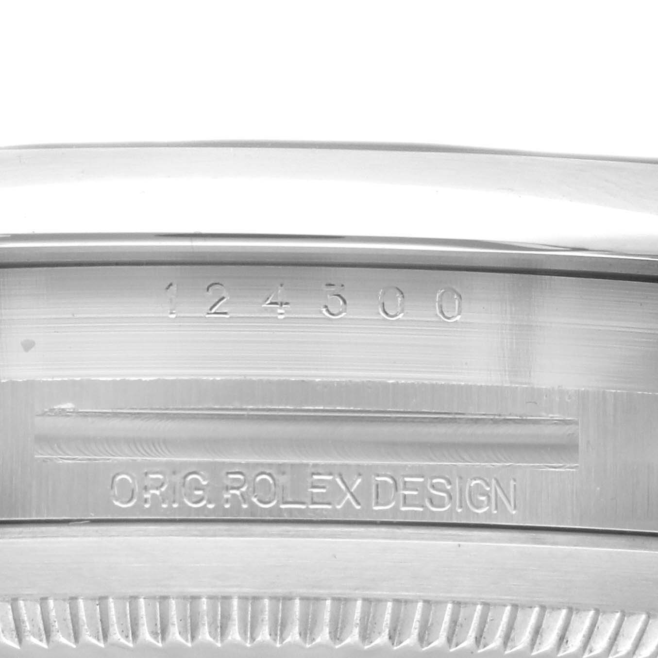 This image shows a close-up of the inner rim of a Rolex Oyster Perpetual 124300 Men's Stainless Steel Silver Dial 124300 Men's Stainless Steel Silver Dial watch case, featuring the model number and "ORIG. ROLEX DESIGN" engraving.