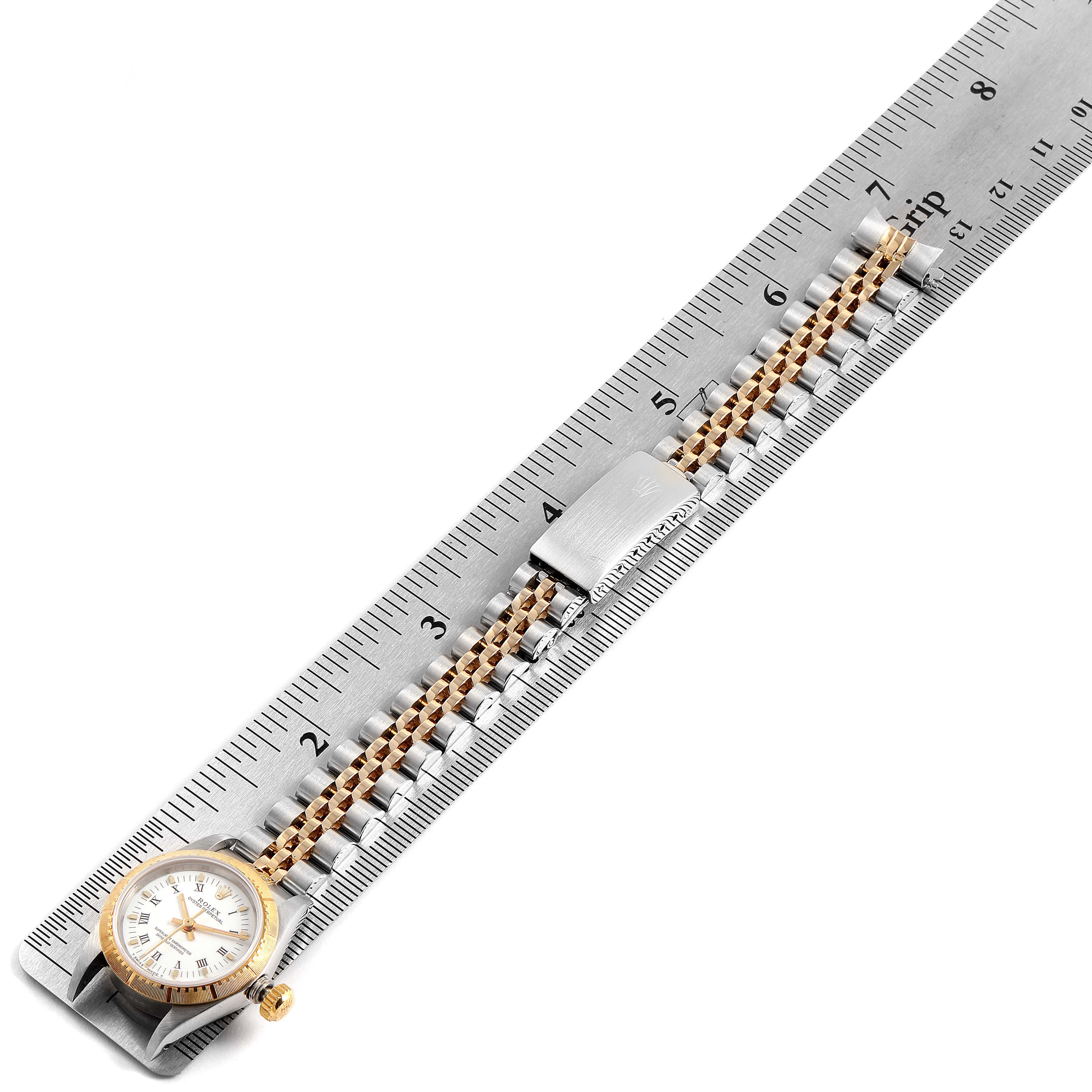 The image shows the Rolex Oyster Perpetual 67243 Women's Steel and Gold (two tone) White Dial 67243 Women's Steel and Gold (two tone) White Dial watch and its band, measured against a ruler from a top-down angle.