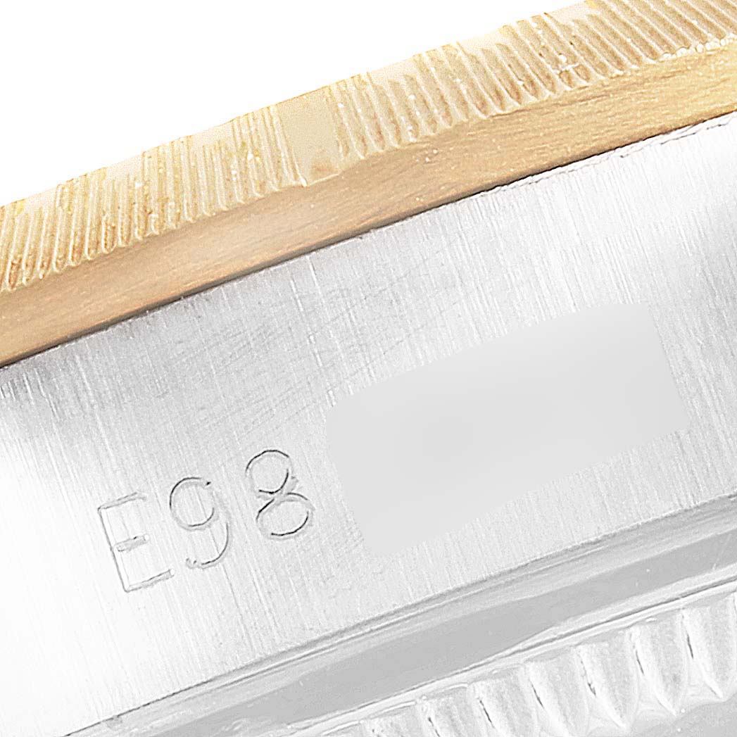 This close-up image shows the side engraving and part of the bezel of a Rolex Oyster Perpetual 67243 Women's Steel and Gold (two tone) White Dial 67243 Women's Steel and Gold (two tone) White Dial watch.