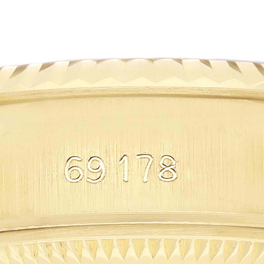 The image shows a close-up of the side of a Rolex President 69178 Men
s Yellow Gold Champagne Dial model, highlighting the serial number engraving.