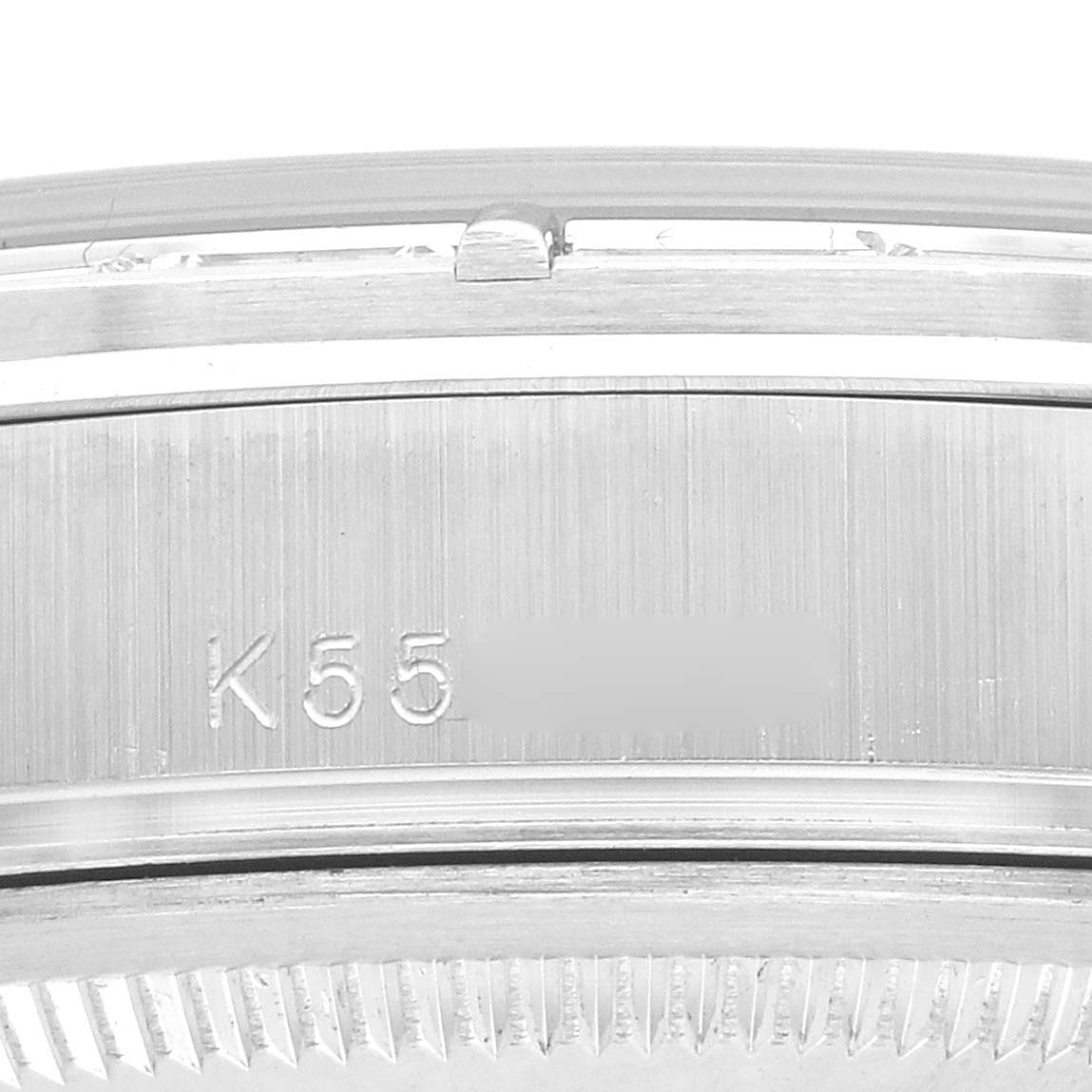 The image shows a close-up of the side and bezel of a Rolex President 118366 Men
s Platinum Blue Dial watch, highlighting its serial number and grooved edge.