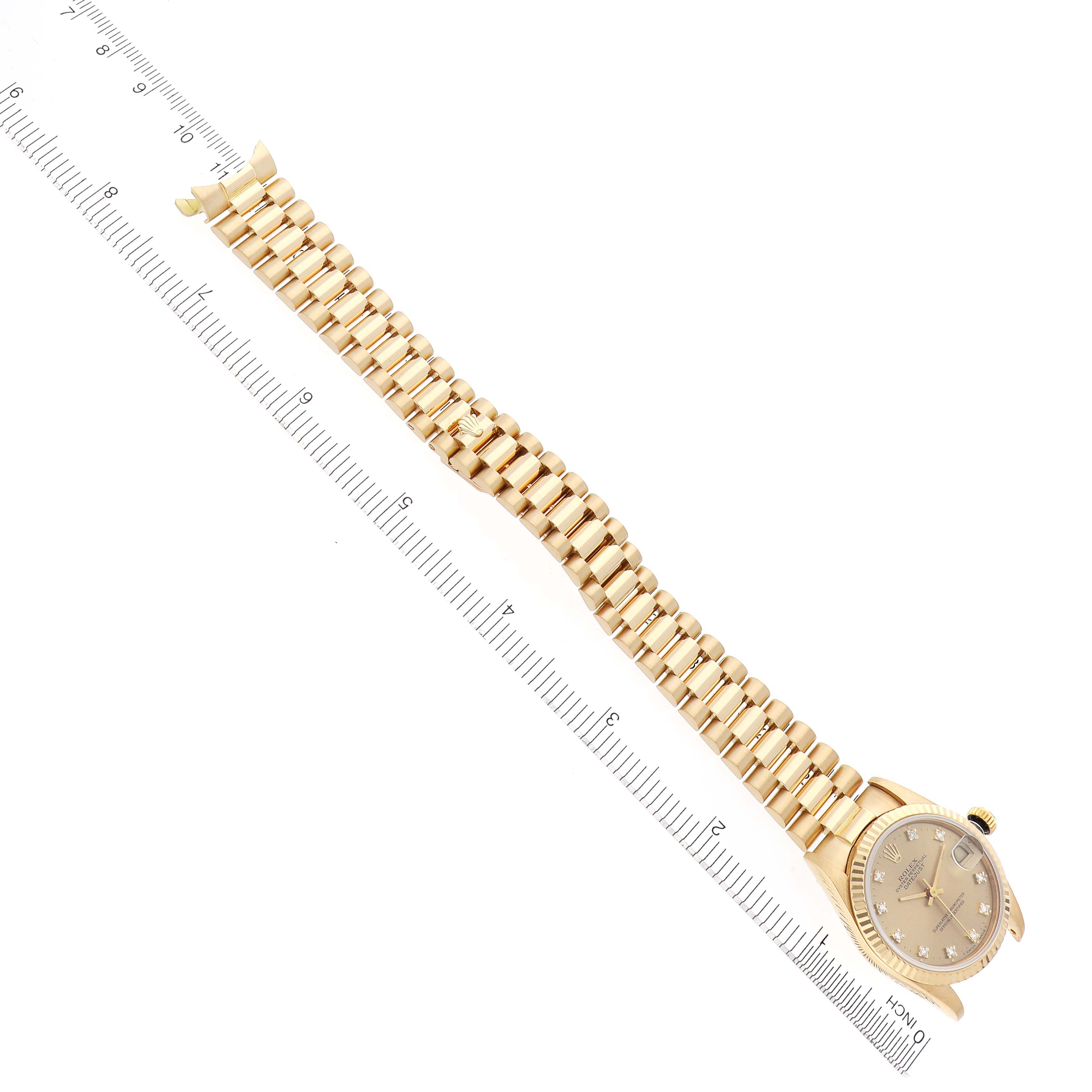 The image shows the Rolex President 68278 Women's Yellow Gold Champagne Dial 68278 Women's Yellow Gold Champagne Dial model watch at an angled top view, displaying the face and full bracelet next to a ruler.