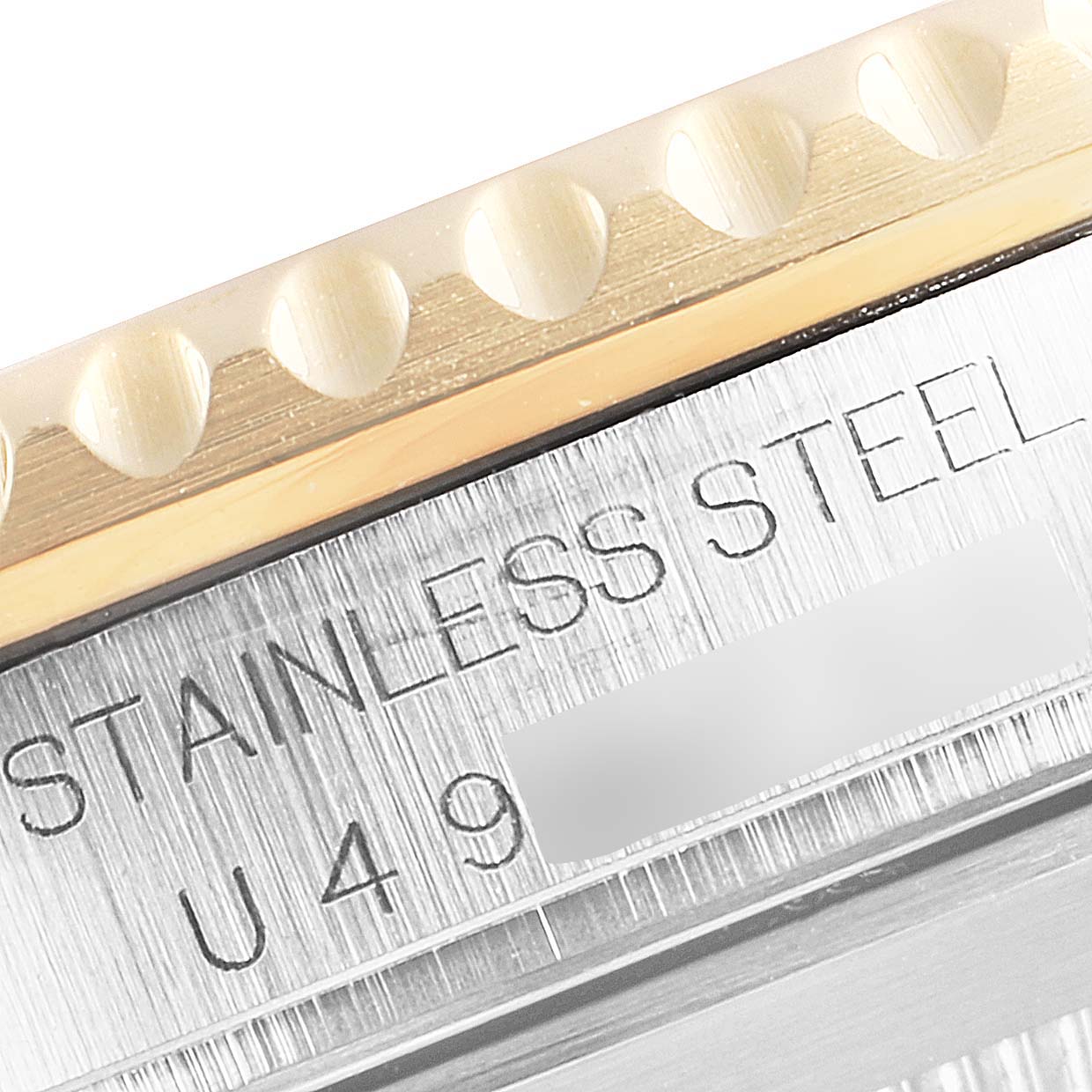 This close-up image shows the engravings on the side of the stainless steel case and the edge of the bezel of the Rolex Submariner 16613 Men's Steel and Gold (two tone) Blue Dial 16613 Men's Steel and Gold (two tone) Blue Dial.