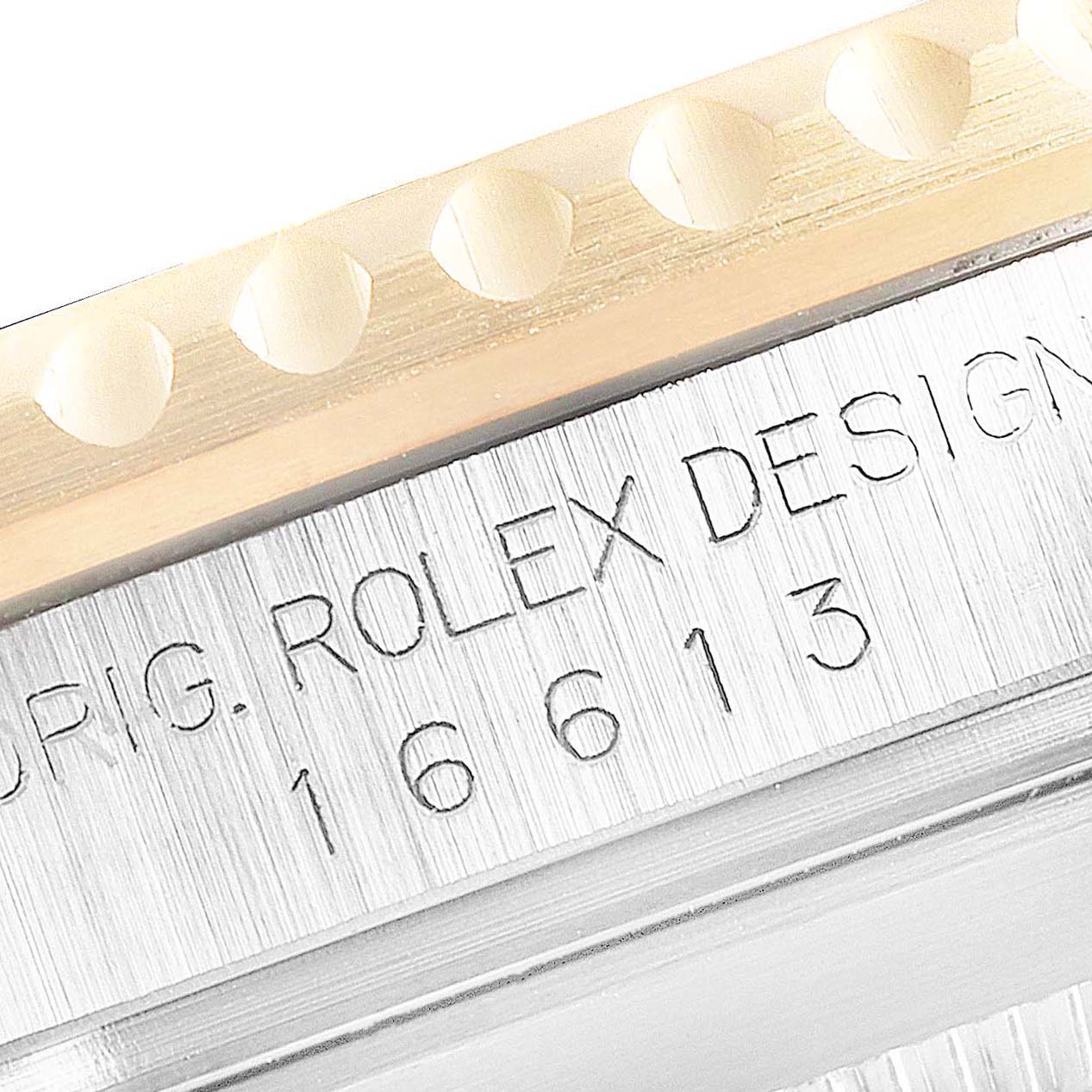 Close-up of a Rolex Submariner 16613 Men's Steel and Gold (two tone) Blue Dial 16613 Men's Steel and Gold (two tone) Blue Dial's model number (16613) engraved on the case, with part of the bezel showing.