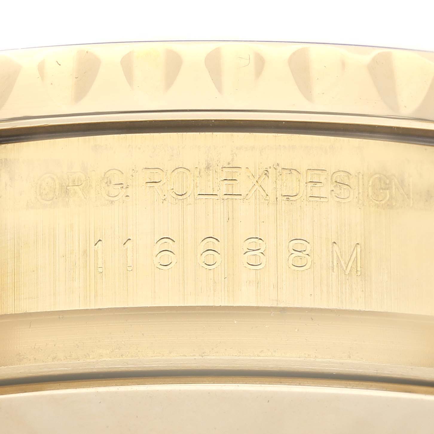 The image shows a close-up of the Rolex Yacht-Master 116688 Men's Yellow Gold White Dial 116688 Men's Yellow Gold White Dial model's case edge with engraved design details.