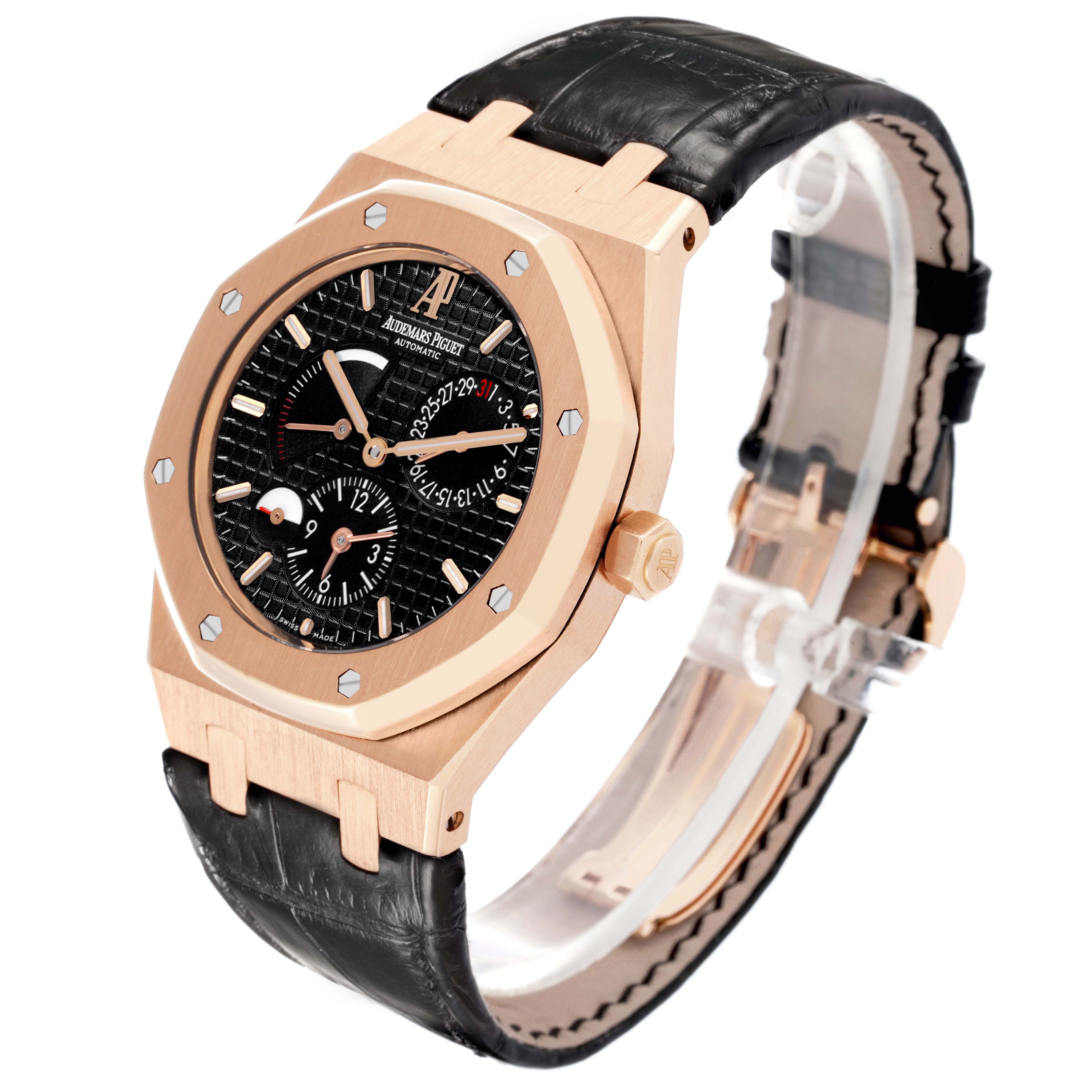The Audemars Piguet Royal Oak 26120OR Men
s Rose Gold Black Dial watch is shown at an angle highlighting the octagonal bezel, dial, crown, and leather strap.
