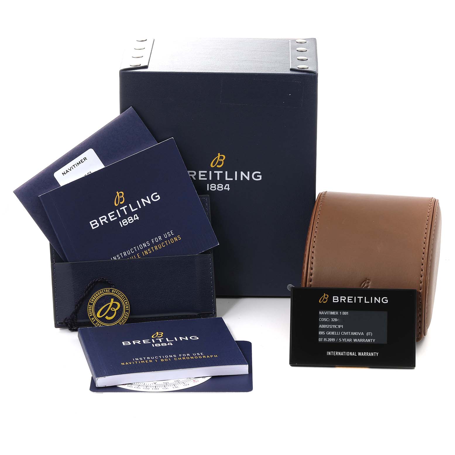 The image shows accessories for a Navitimer Breitling watch, including manuals, an international warranty card, a box, and a leather case.