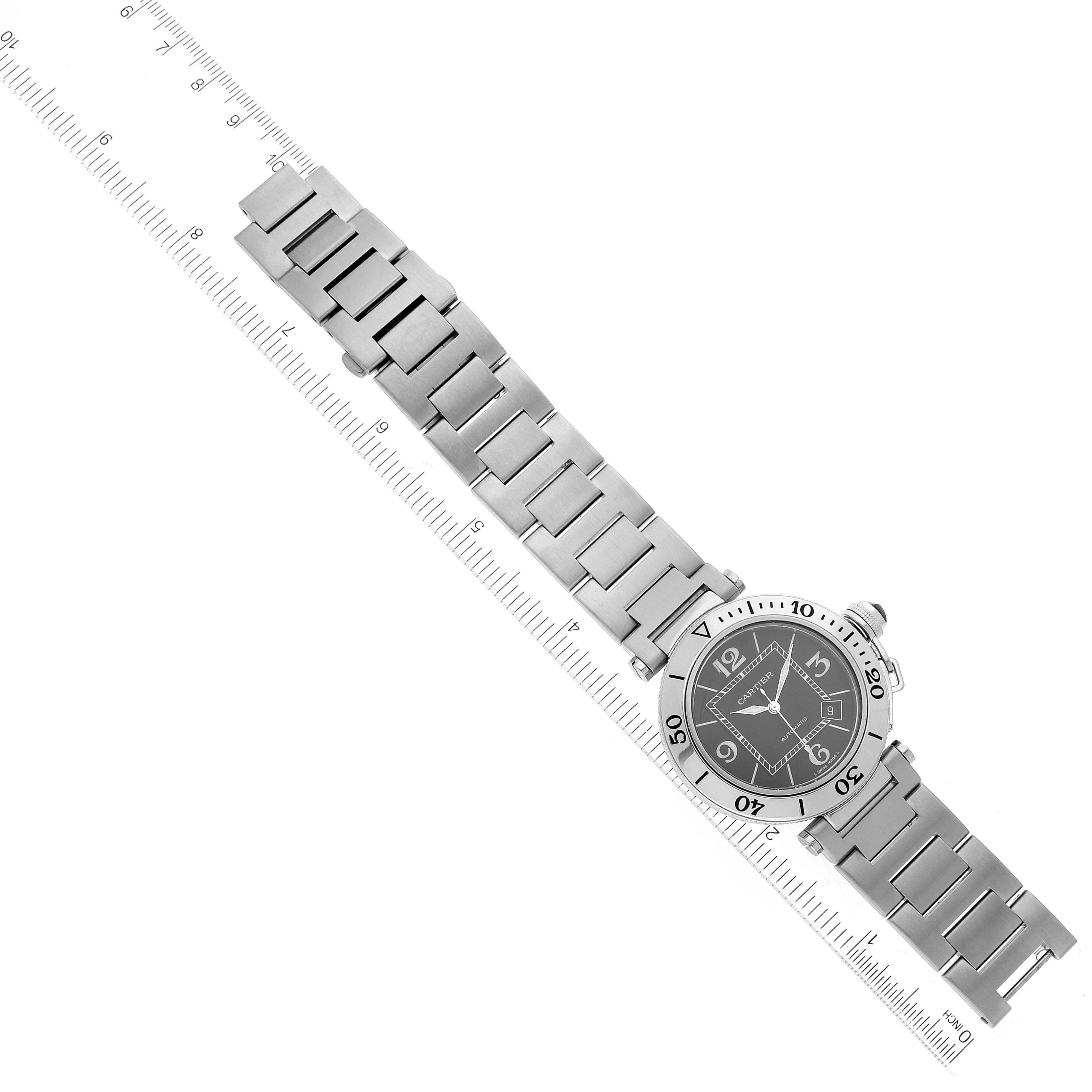 This image shows the Cartier Pasha W31077M7 Men's Stainless Steel Black Dial W31077M7 Men's Stainless Steel Black Dial watch laid flat, with its face and metal bracelet fully visible, aligned with a ruler.