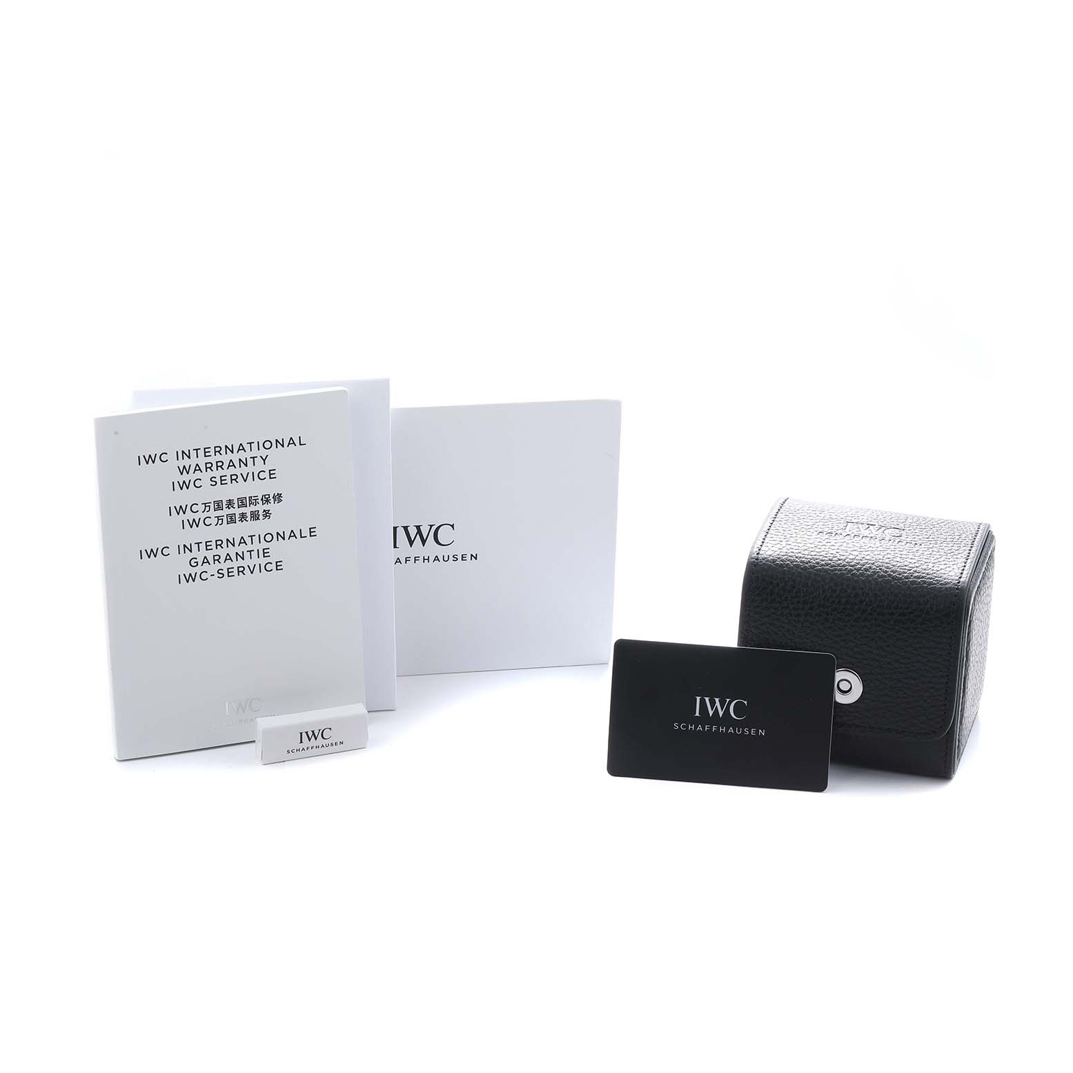 The image shows the IWC Ingenieur IW328903 Men's Stainless Steel Blue Dial watch accessories, including a warranty booklet, card, and a black case.