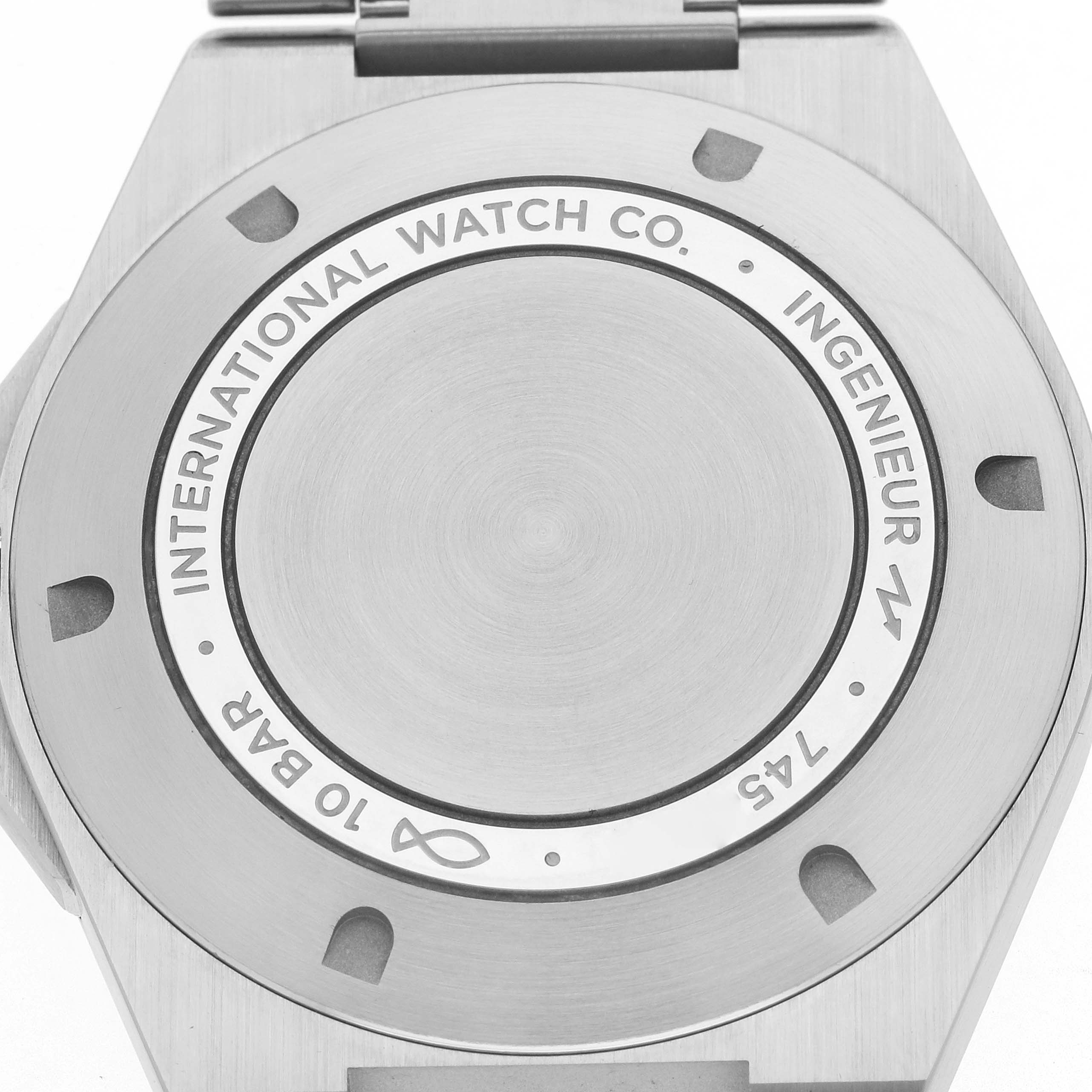 The image shows the case back of an IWC Ingenieur IW328903 Men's Stainless Steel Blue Dial watch, featuring engravings and screws.