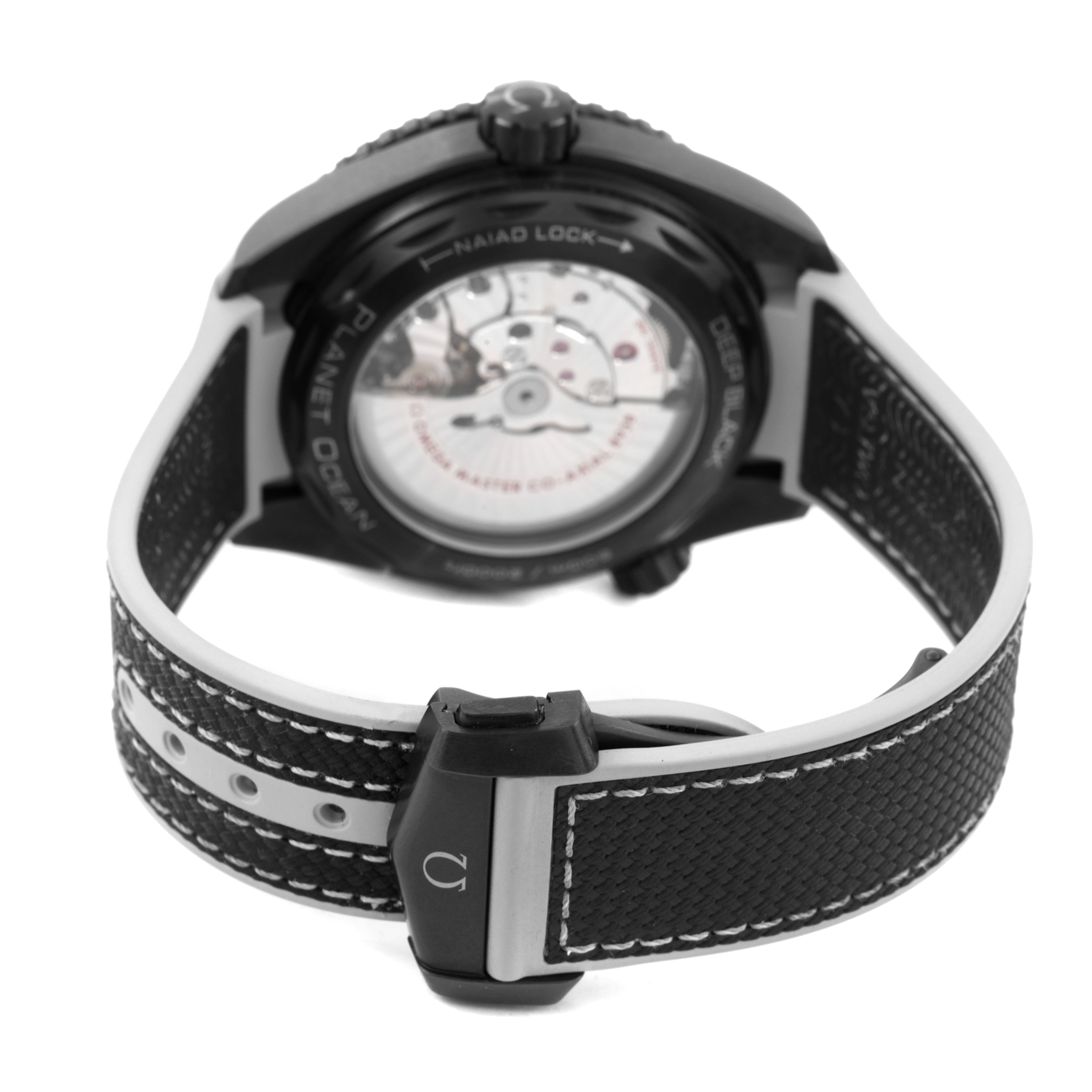 The Omega Planet Ocean 215.92.46.22.01.007 Men's Ceramic Black Dial watch is shown from the back, highlighting the clasp, strap, and case back with visible interior mechanics.