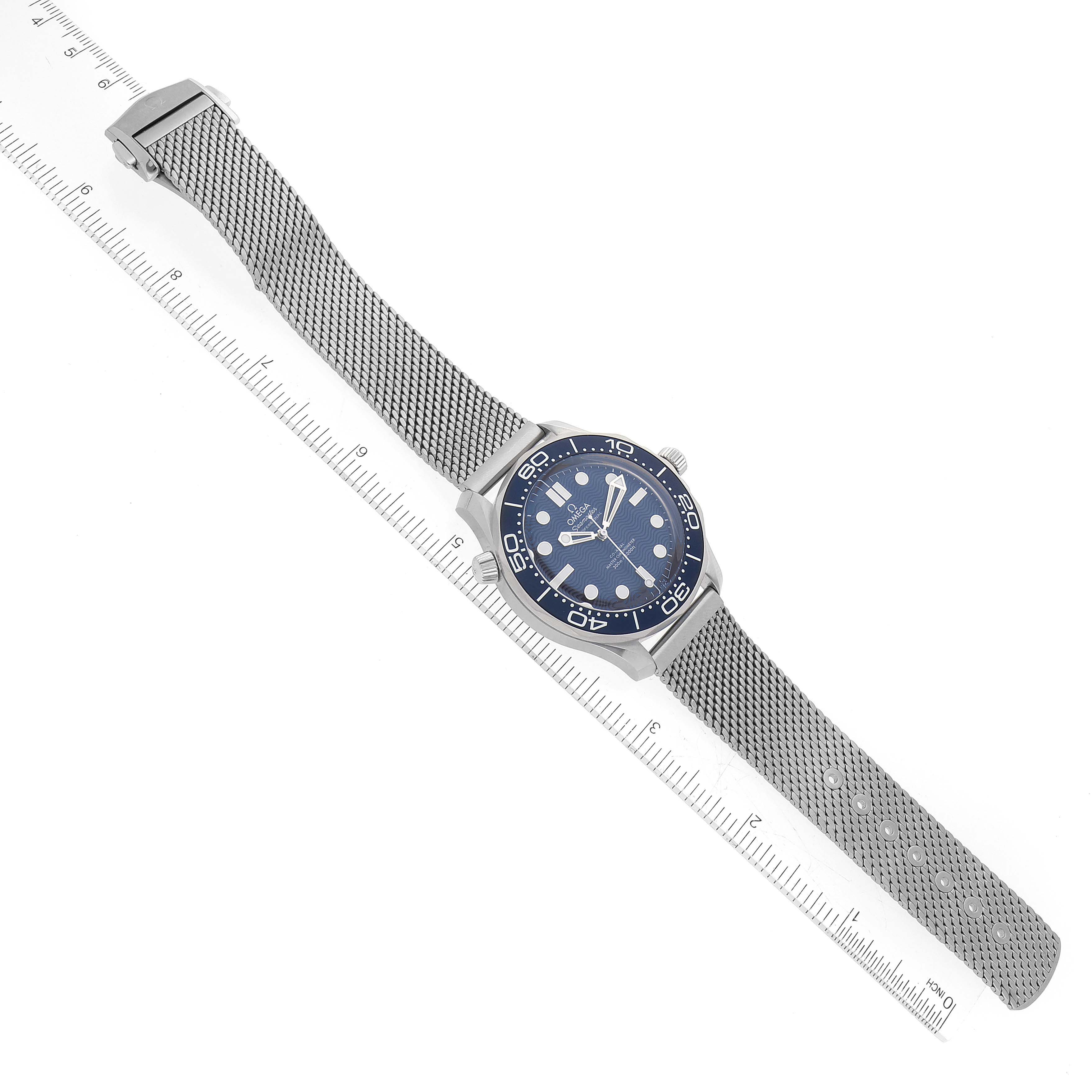 The image shows an angled top-down view of the Omega Seamaster 210.30.42.20.03.002 Men's Stainless Steel Blue Dial 210.30.42.20.03.002 Men's Stainless Steel Blue Dial watch, focusing on the dial, bezel, and mesh strap.