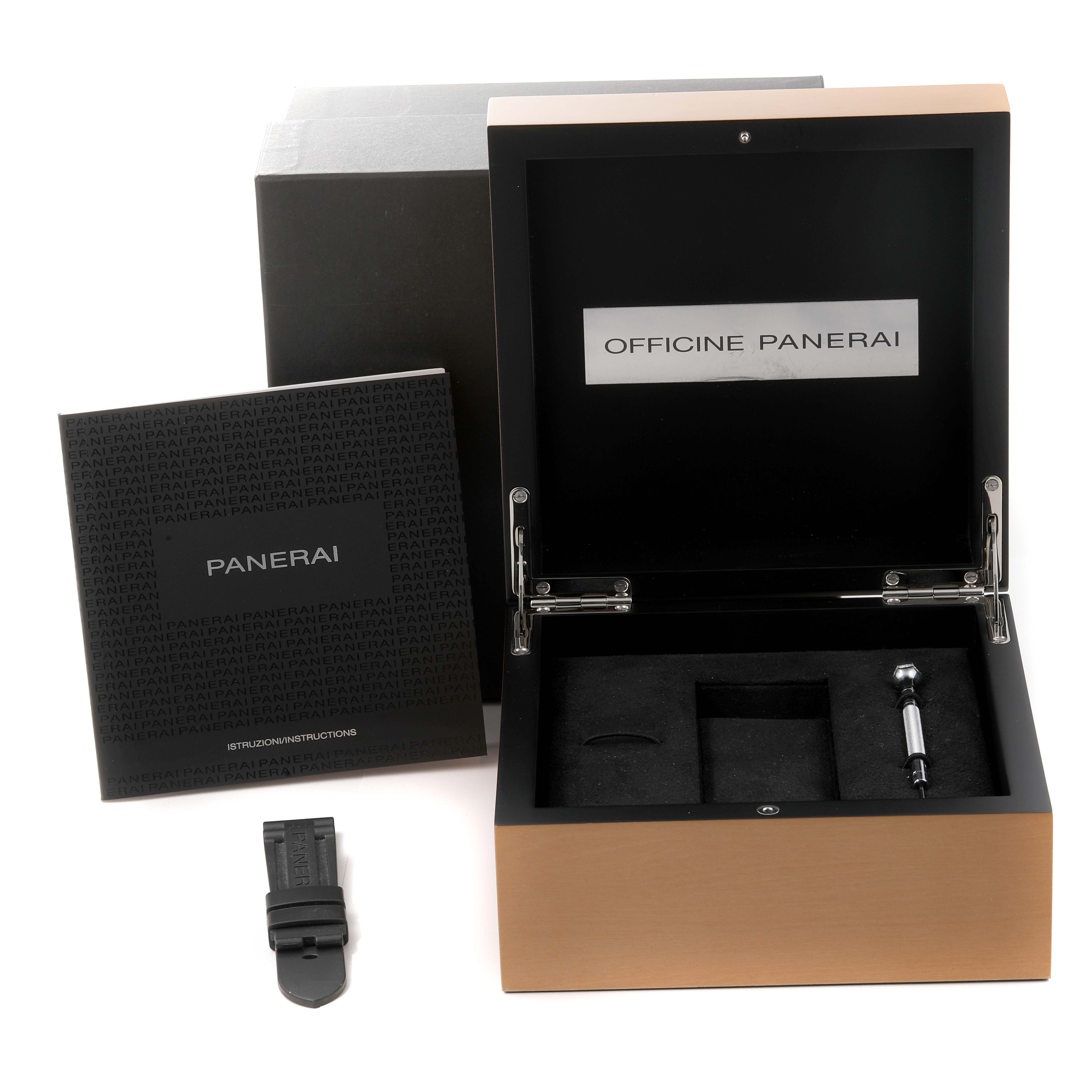 The image shows a top-down view of the Luminor by Panerai watch box, booklet, extra strap, and tool.