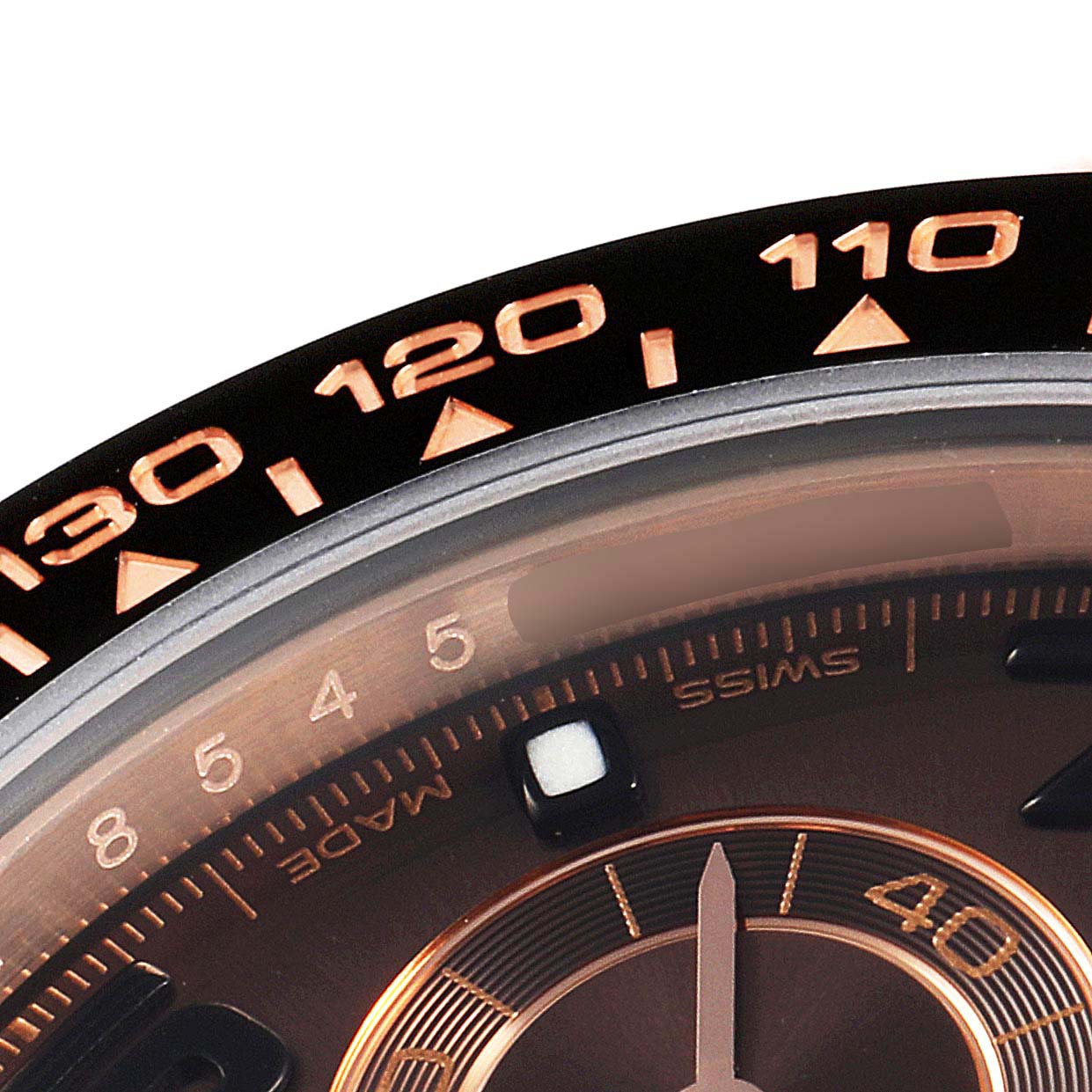 The image shows a close-up of the bezel and partial dial of a Rolex Daytona 116515LN Men's Rose Gold Brown Dial 116515LN Men's Rose Gold Brown Dial watch, displaying the 110-130 tachymeter markings.