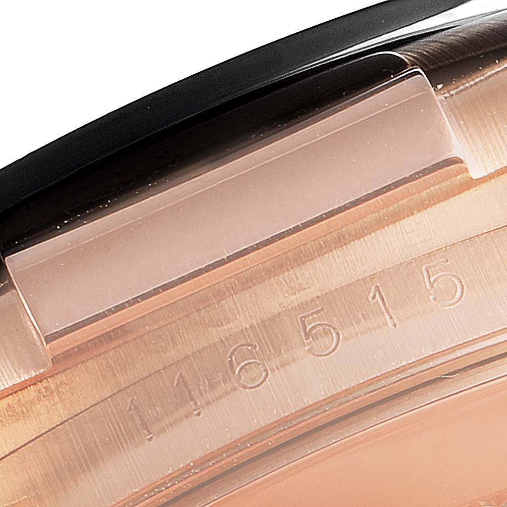 This close-up image of the Rolex Daytona 116515LN Men's Rose Gold Brown Dial 116515LN Men's Rose Gold Brown Dial watch shows part of the bezel and case with an engraved serial number.