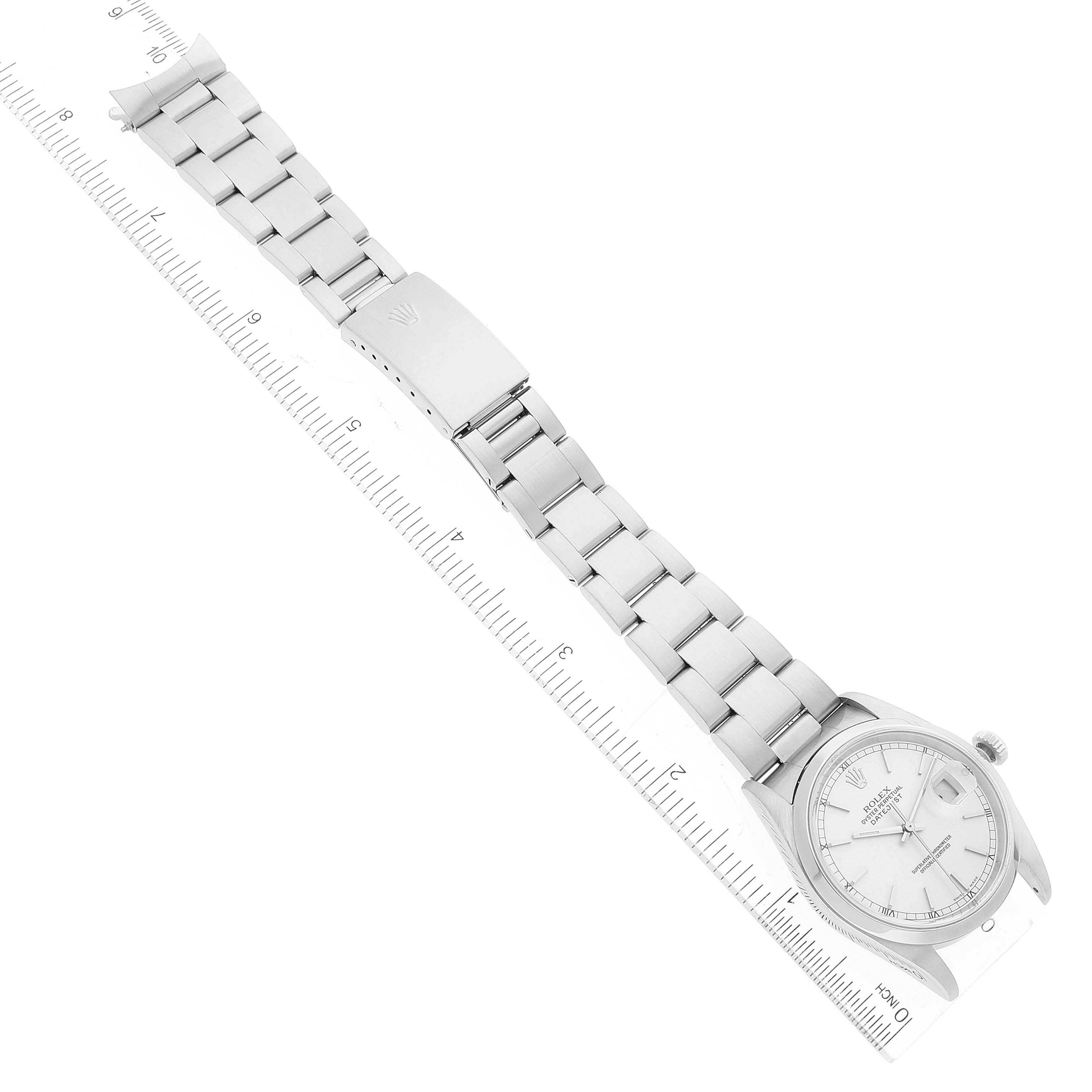 The image shows a Rolex Datejust 16200 Men's Stainless Steel Silver Dial 16200 Men's Stainless Steel Silver Dial watch placed diagonally beside a ruler, fully displaying its bracelet and clasp.