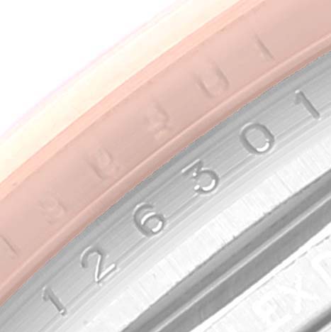 This close-up image shows part of the Rolex Datejust 41 126301 Men's Steel and Gold (two tone) Brown Dial 126301 Men's Steel and Gold (two tone) Brown Dial model's bezel and the engraved serial number.