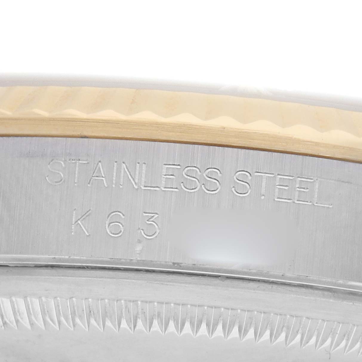 The image shows a close-up of the stainless steel side and engraved details of a Rolex Datejust 16233 Men
s Steel and Gold (two tone) Silver Dial watch.