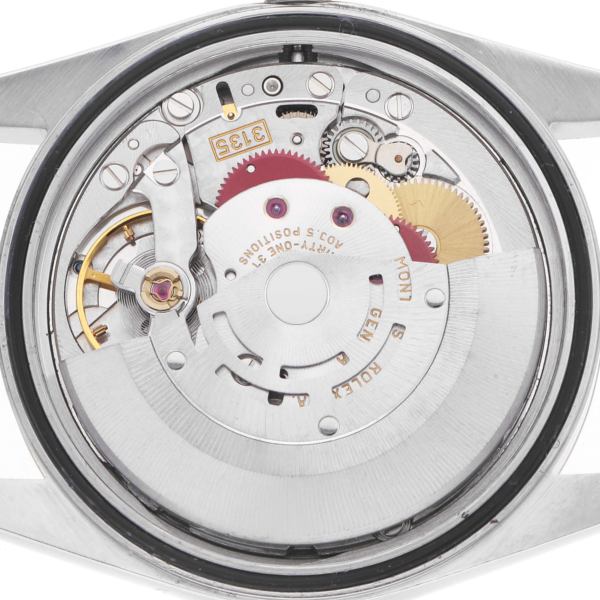 The image shows the movement of a Rolex Datejust 16233 Men
s Steel and Gold (two tone) Silver Dial watch from a rear angle, highlighting gears and components.