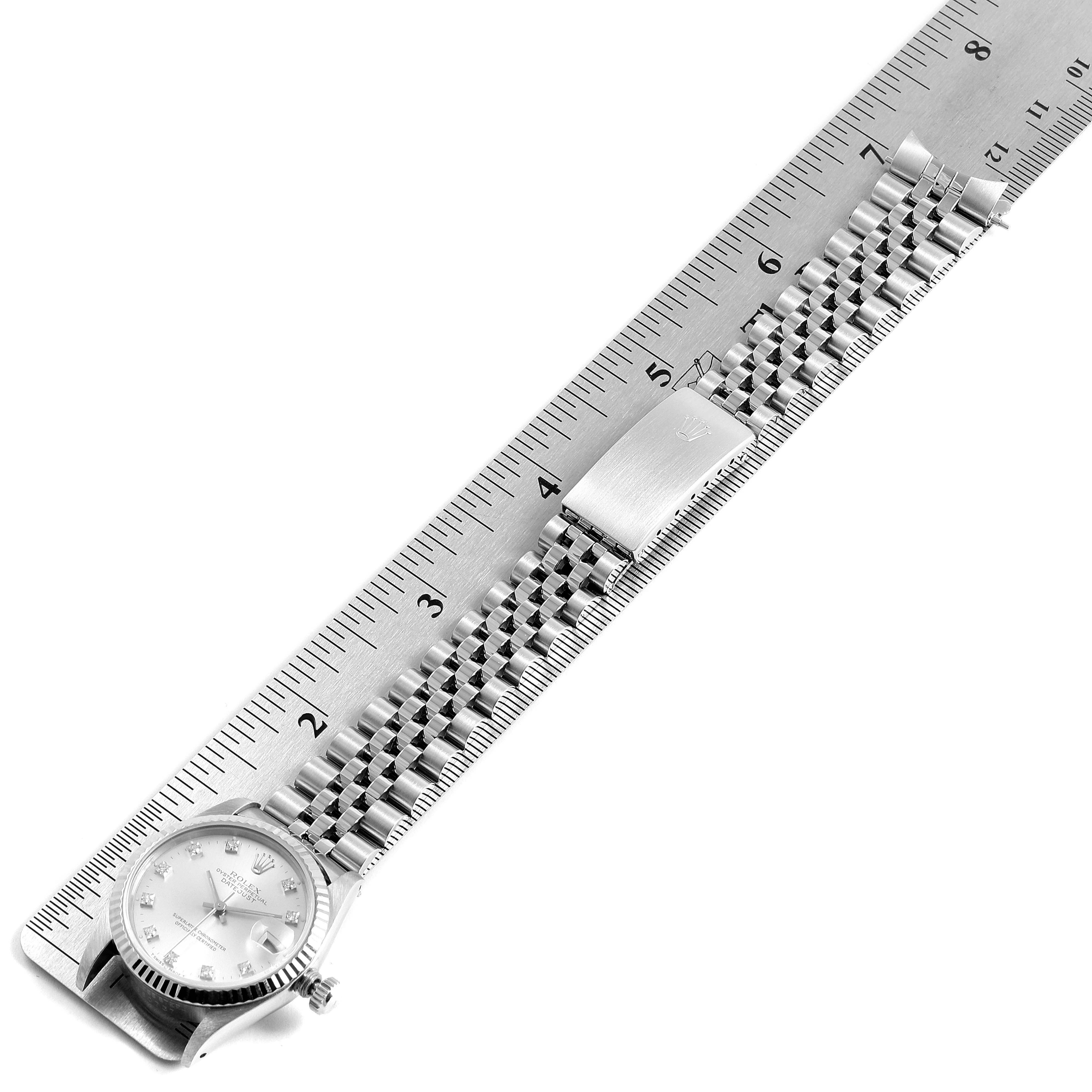 The image shows a Rolex Mid-Size 68274 Women's Stainless Steel Silver Dial 68274 Women's Stainless Steel Silver Dial model watch placed flat along a ruler, showcasing the face, bracelet, and clasp.