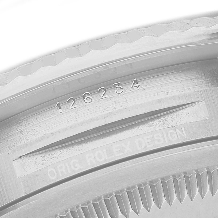 The image shows a close-up of the serial number and "Orig Rolex Design" engraving on the Rolex Datejust 126234 Men's Stainless Steel Blue Dial model’s case edge.