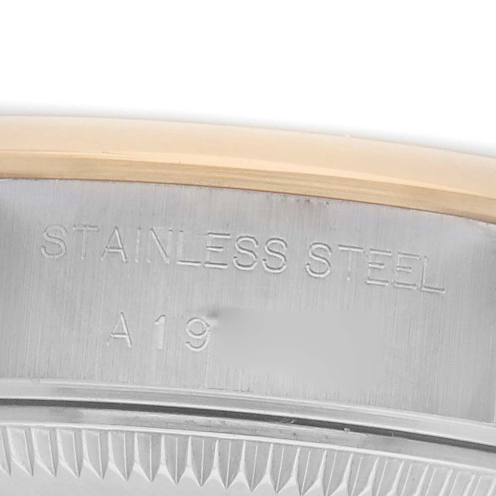 The image shows a close-up of the side of a Rolex Datejust 79163 Women
s Steel and Gold (two tone) Silver Dial watch case, focusing on the stainless steel engraving.