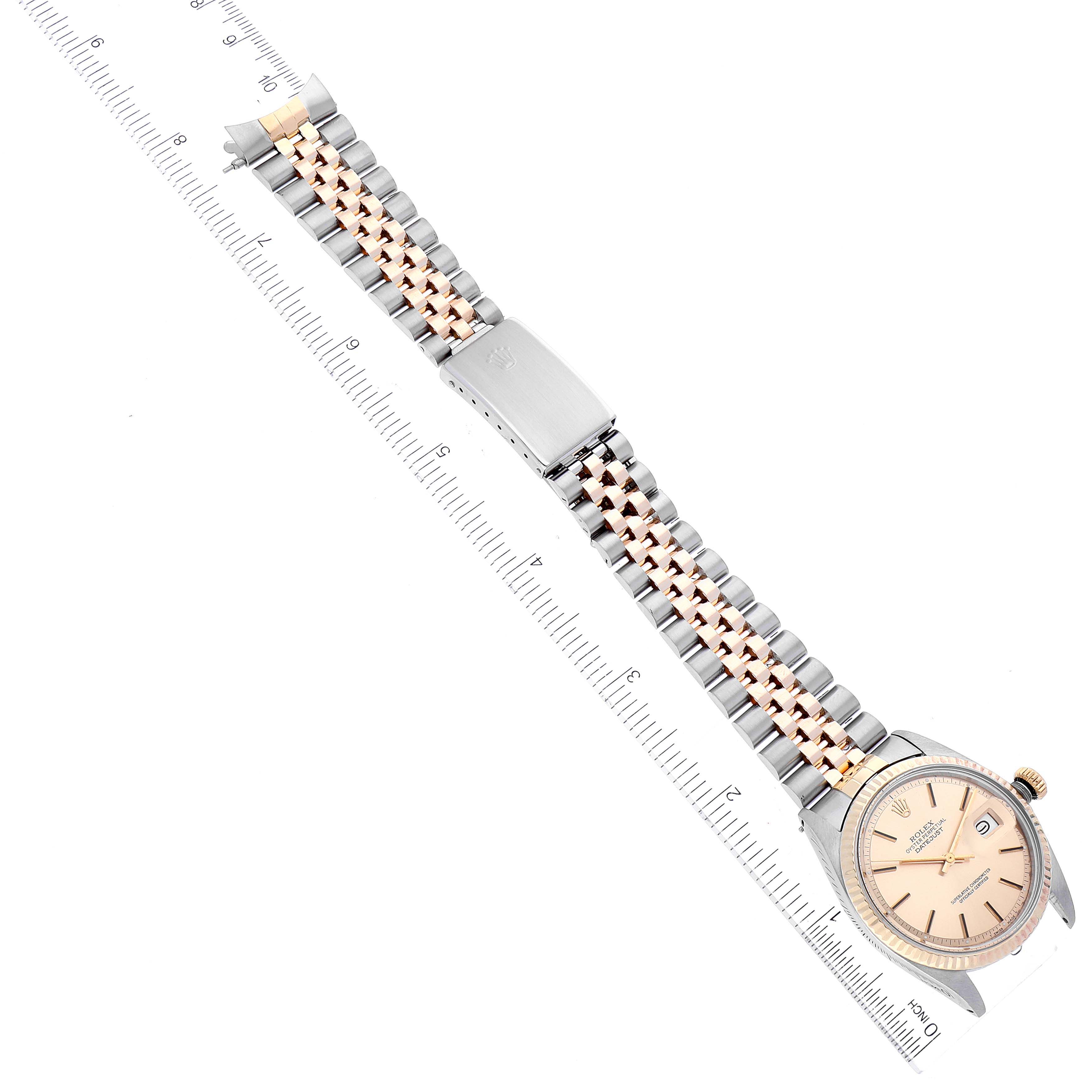 The image features a Vintage Collection Rolex watch with a ruler aligned parallel, displaying its face and jubilee bracelet from an overhead angle.
