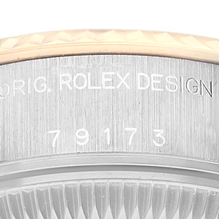 The image shows a close-up of the side of a Rolex Datejust 79173 Women's Steel and Gold (two tone) Champagne Dial 79173 Women's Steel and Gold (two tone) Champagne Dial watch, displaying the model number and "ROLEX DESIGN" engraving.