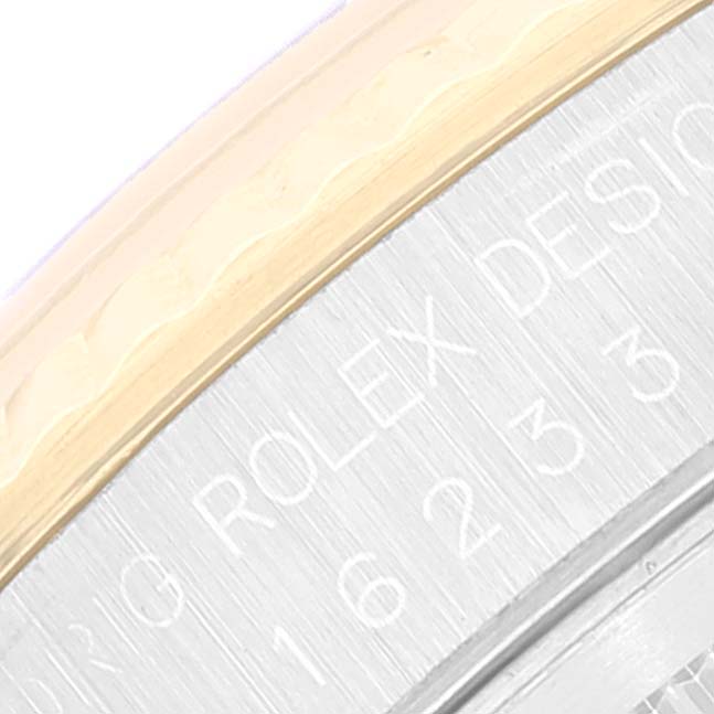 This close-up of the Rolex Datejust 16233 Men's Steel and Gold (two tone) Champagne Dial 16233 Men's Steel and Gold (two tone) Champagne Dial watch shows the engraved bezel and part of the case.