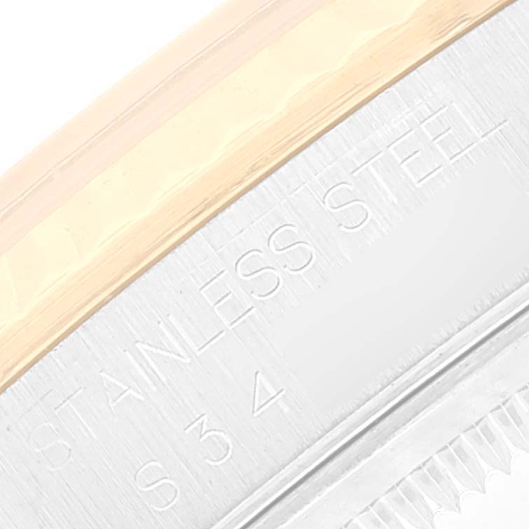 The image shows a macro close-up of the bezel and case side of a Rolex Datejust 16233 Men's Steel and Gold (two tone) Champagne Dial 16233 Men's Steel and Gold (two tone) Champagne Dial watch, focusing on the "STAINLESS STEEL" engraving.