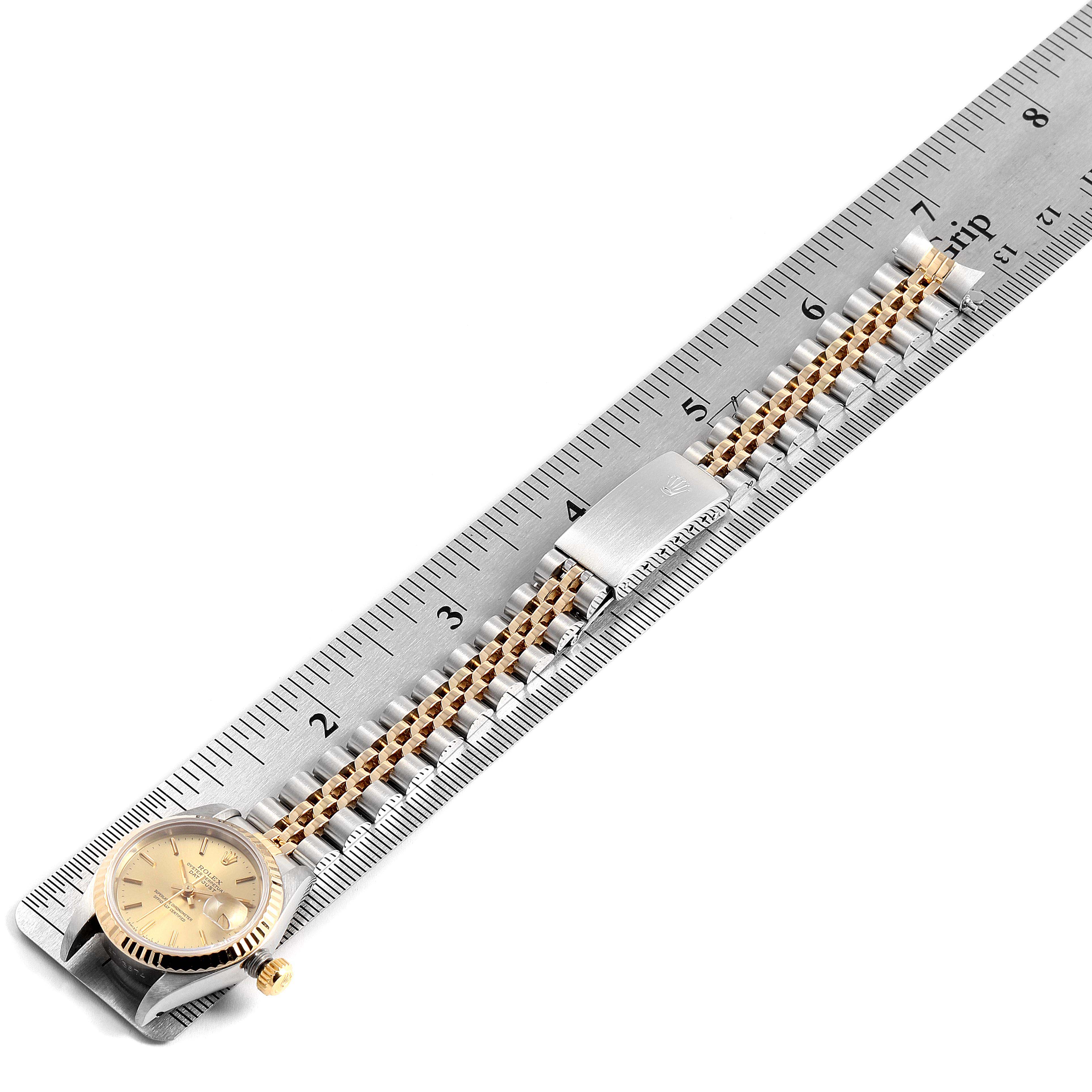 The image shows a Rolex Datejust 69173 Women's Steel and Gold (two tone) Champagne Dial 69173 Women's Steel and Gold (two tone) Champagne Dial watch and its bracelet partly stretched along a ruler, viewed from above.