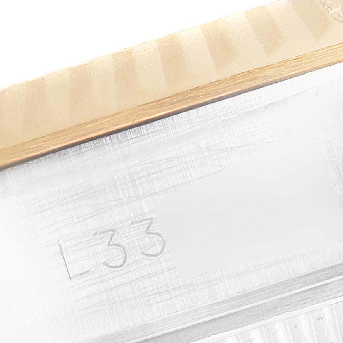 The image shows a close-up of the side of a Rolex Datejust 69173 Women's Steel and Gold (two tone) Champagne Dial 69173 Women's Steel and Gold (two tone) Champagne Dial watch, focusing on the engraved serial number.