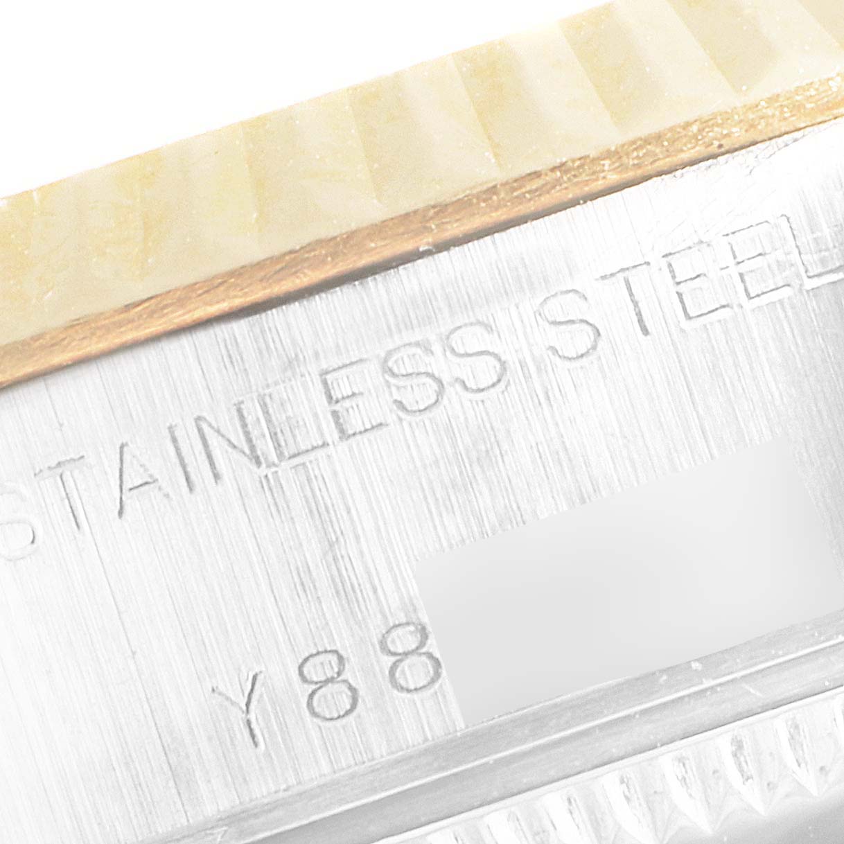 This close-up image of a Rolex Datejust 79173 Women's Steel and Gold (two tone) Mother of Pearl Dial 79173 Women's Steel and Gold (two tone) Mother of Pearl Dial watch shows part of the bezel and the engraved stainless steel.