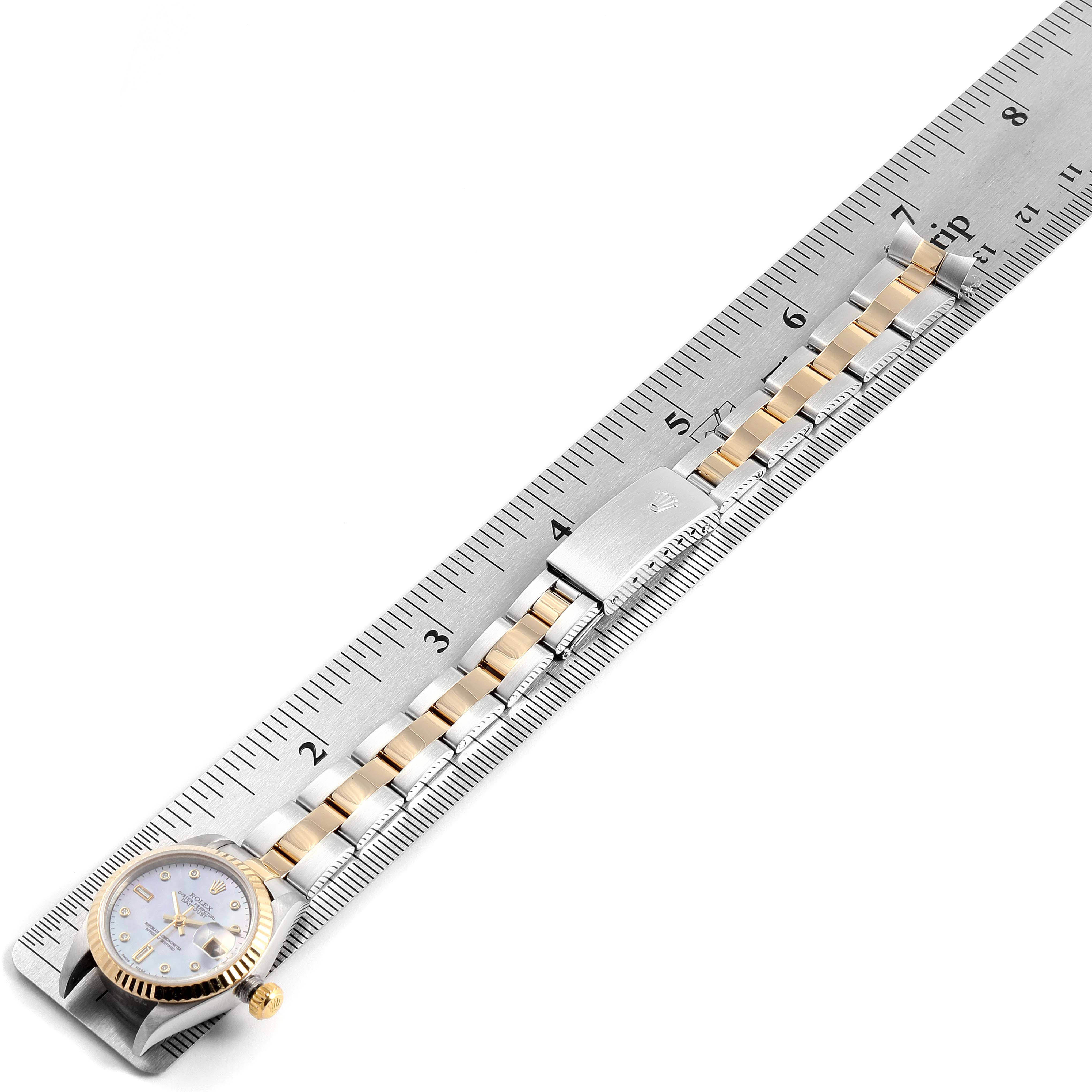 The image shows a Rolex Datejust 79173 Women's Steel and Gold (two tone) Mother of Pearl Dial 79173 Women's Steel and Gold (two tone) Mother of Pearl Dial watch laid against a ruler, displaying the watch face, bezel, crown, and bracelet.
