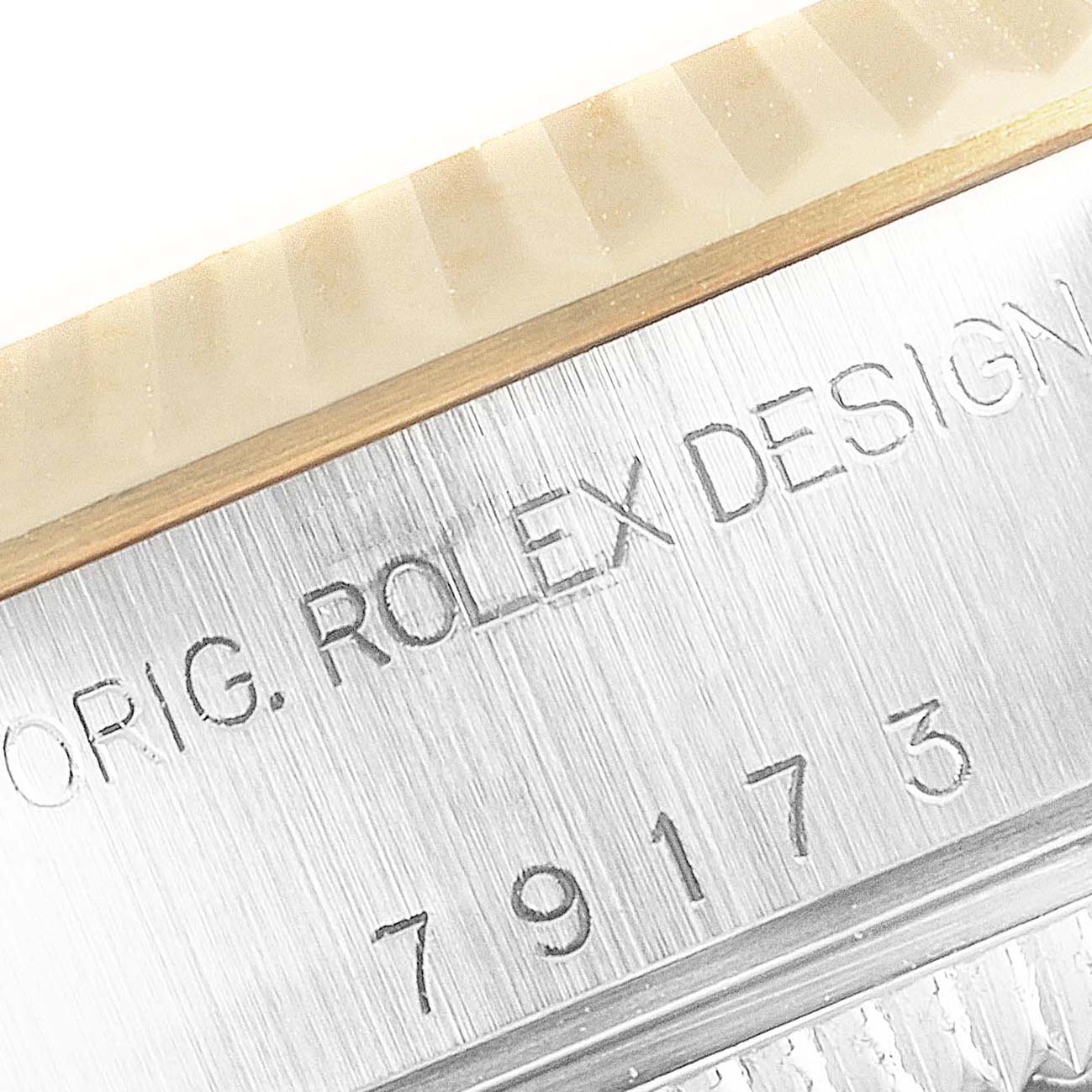 The image shows a close-up of the engraving on the case side of a Rolex Datejust 79173 Women's Steel and Gold (two tone) Mother of Pearl Dial 79173 Women's Steel and Gold (two tone) Mother of Pearl Dial watch.